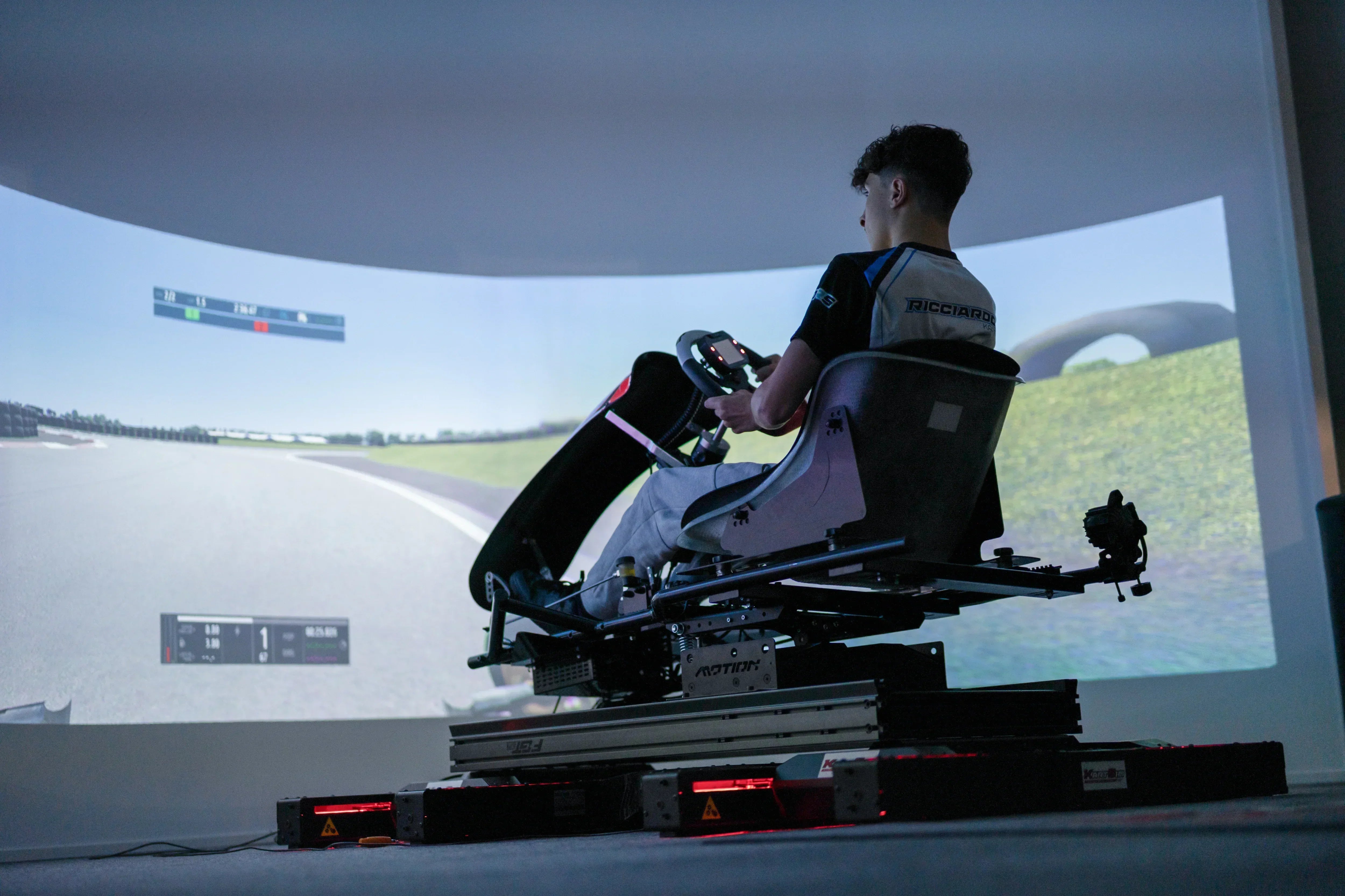 Driver using a KartSim Pro realistic kart simulator with telemetry feedback for professional karting performance training.
