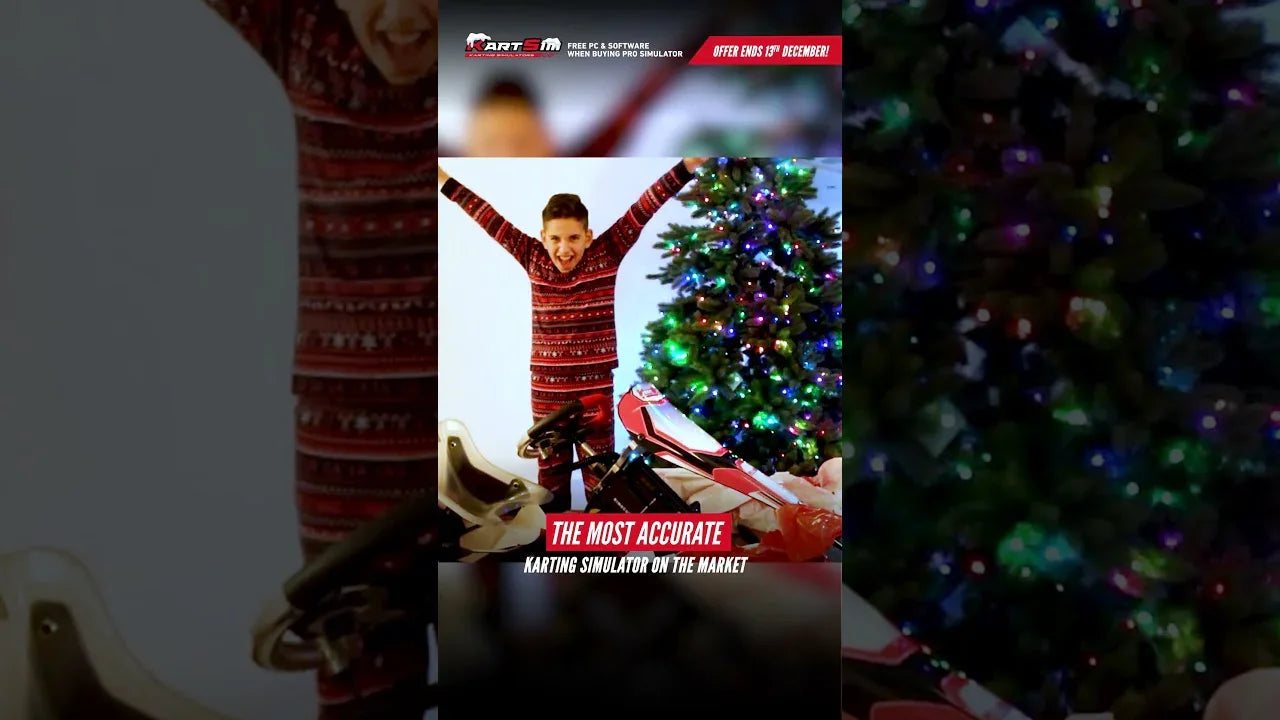 Young kart driver celebrating next to a professional kart simulator rig by a Christmas tree, highlighting karting training realism.