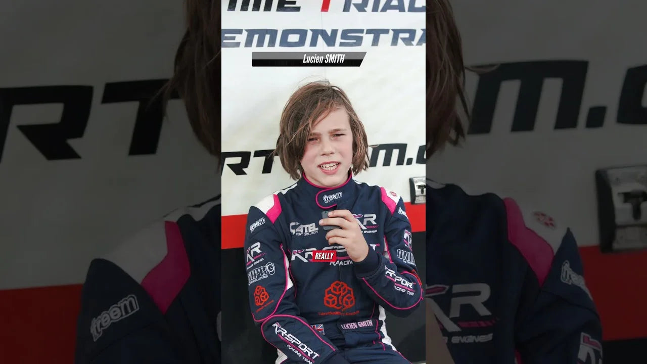Young kart driver in professional race suit during karting training interview, focused on driver development