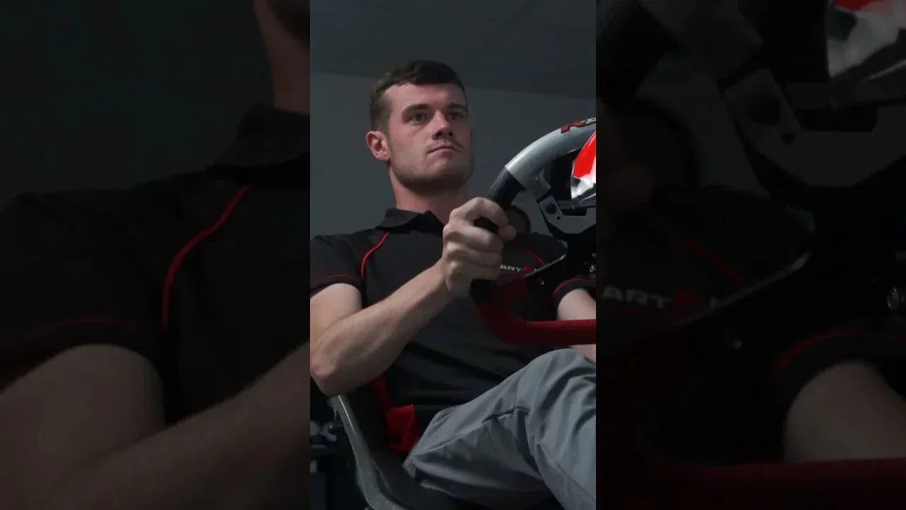 Focused kart driver using professional kart simulator in realistic racing seat for driver training.