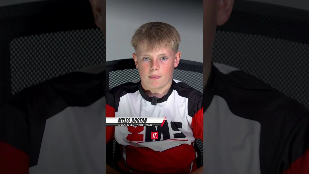 Youth kart driver sitting upright in a professional karting training environment for simulator practice.