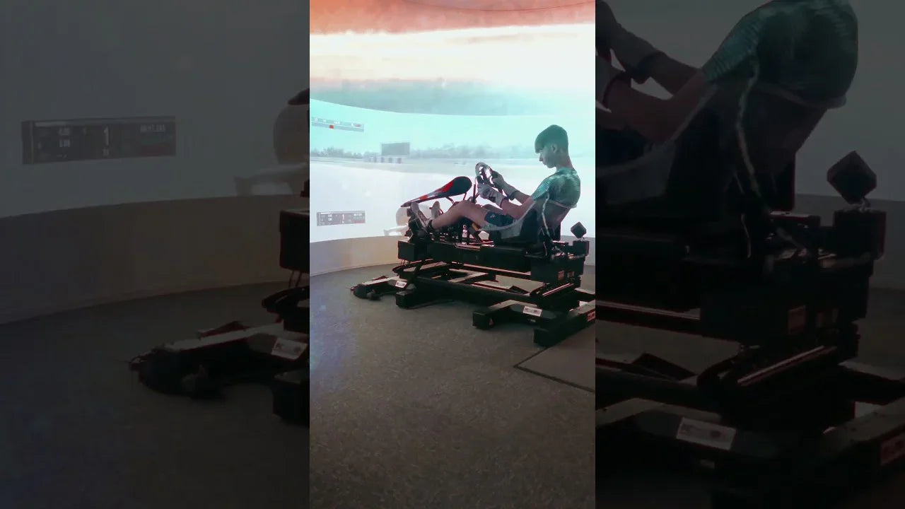 Professional kart simulator with realistic chassis, driver training posture, projected racing track environment