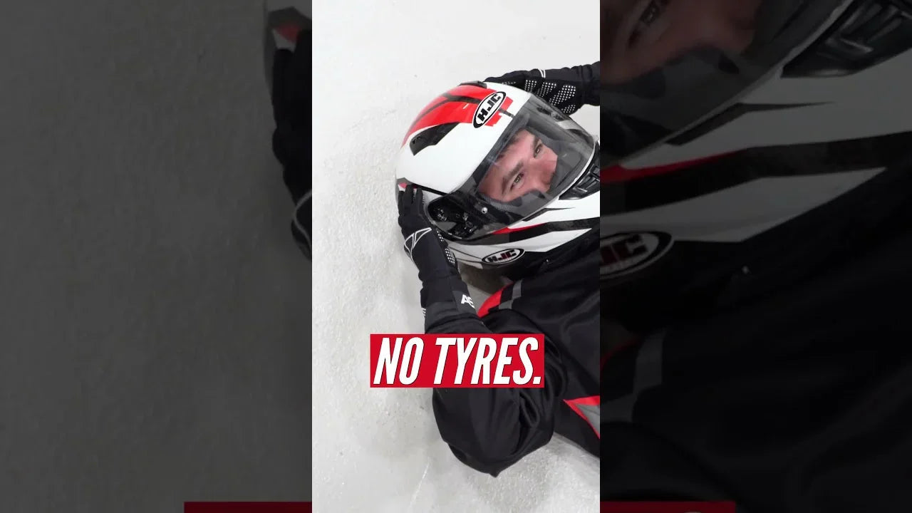 Kart driver in racing helmet and suit lying on track, professional karting training environment