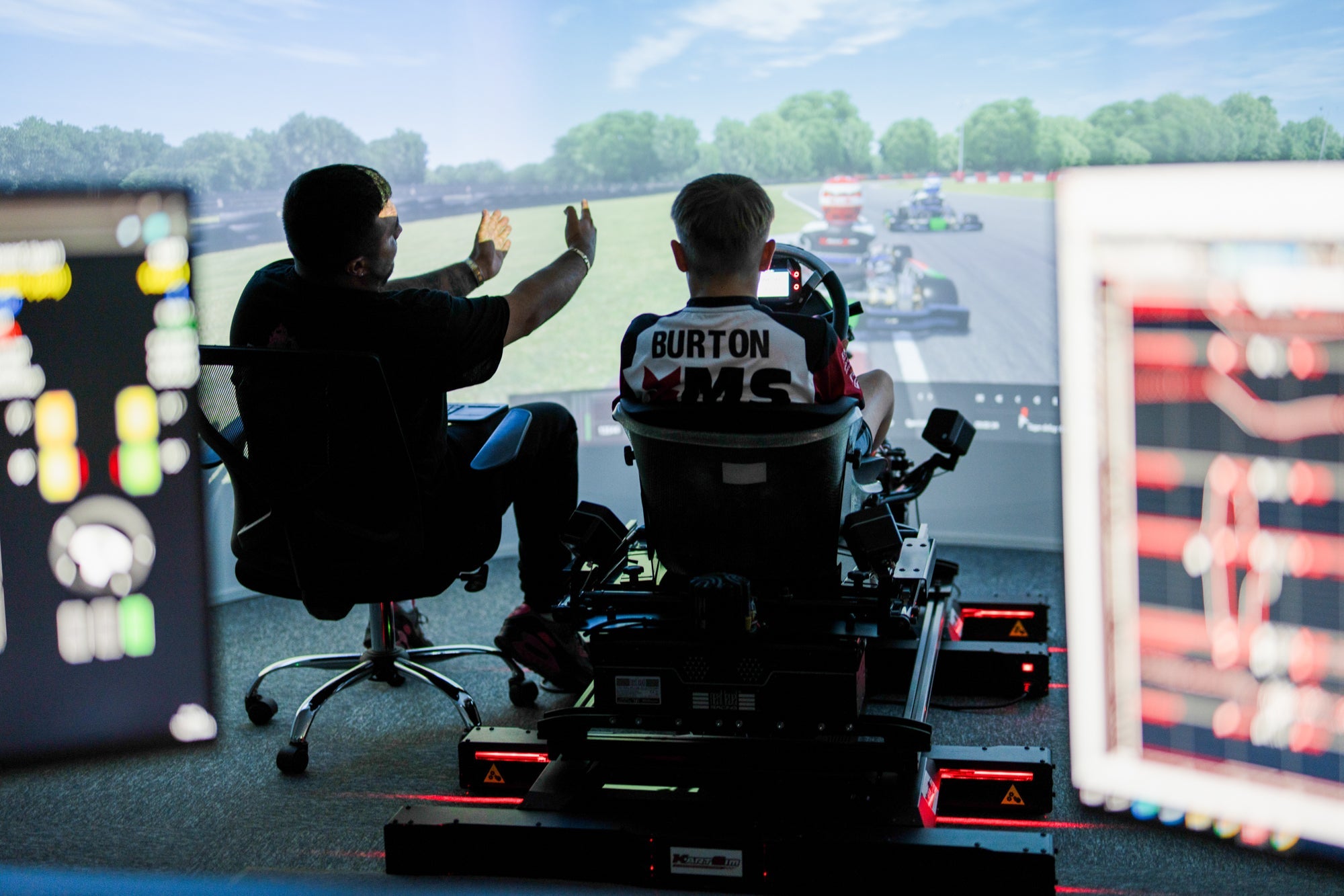 Professional kart simulator rig with realistic seating, driver training and racing telemetry on screens
