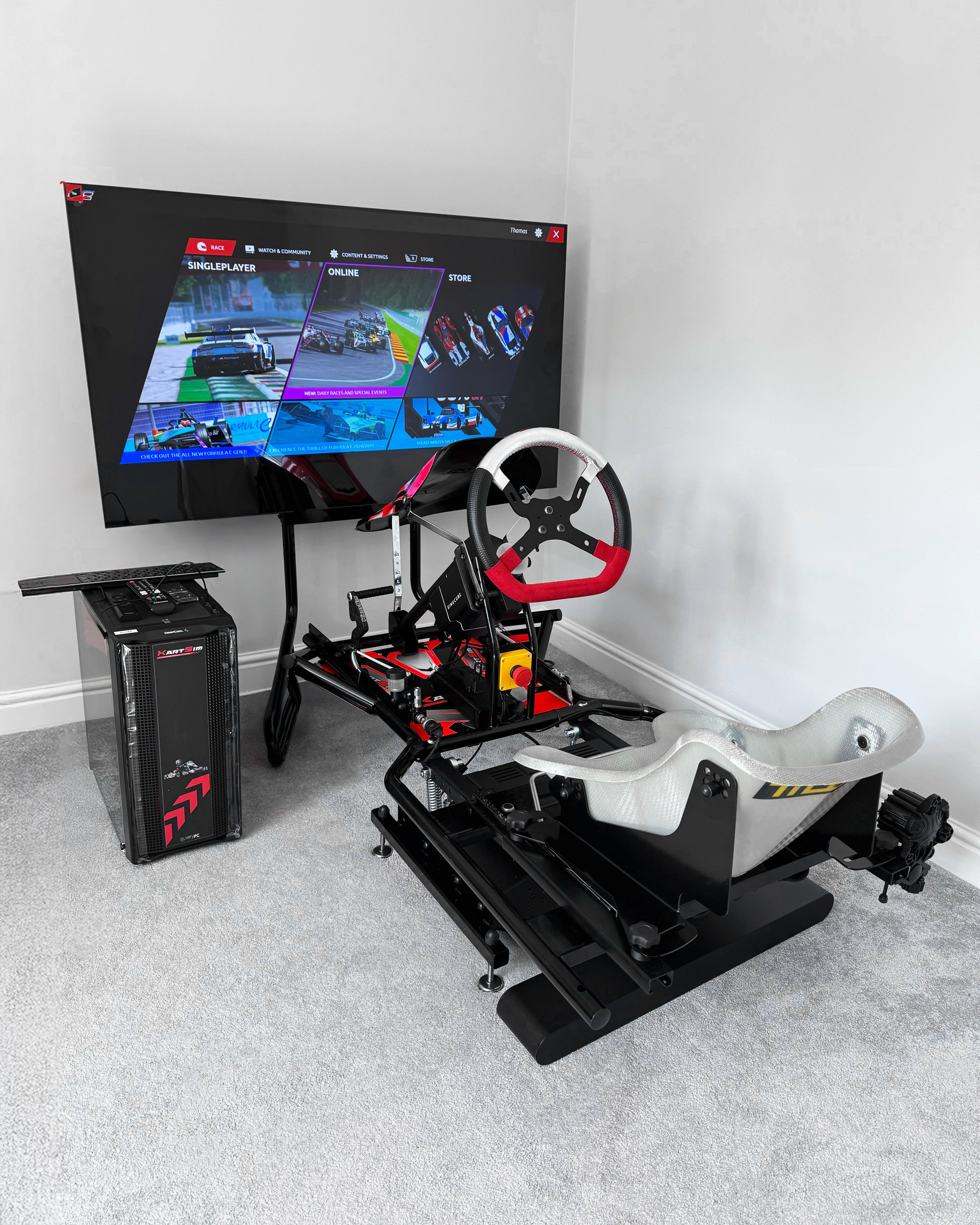 KartSim Pro Simulator delivered and installed for a customer: full-size kart frame with adjustable seat, race pedals and steering wheel, paired with a large display and KartSim PC running the software menu—professional equipment used as a training tool for kart racers.