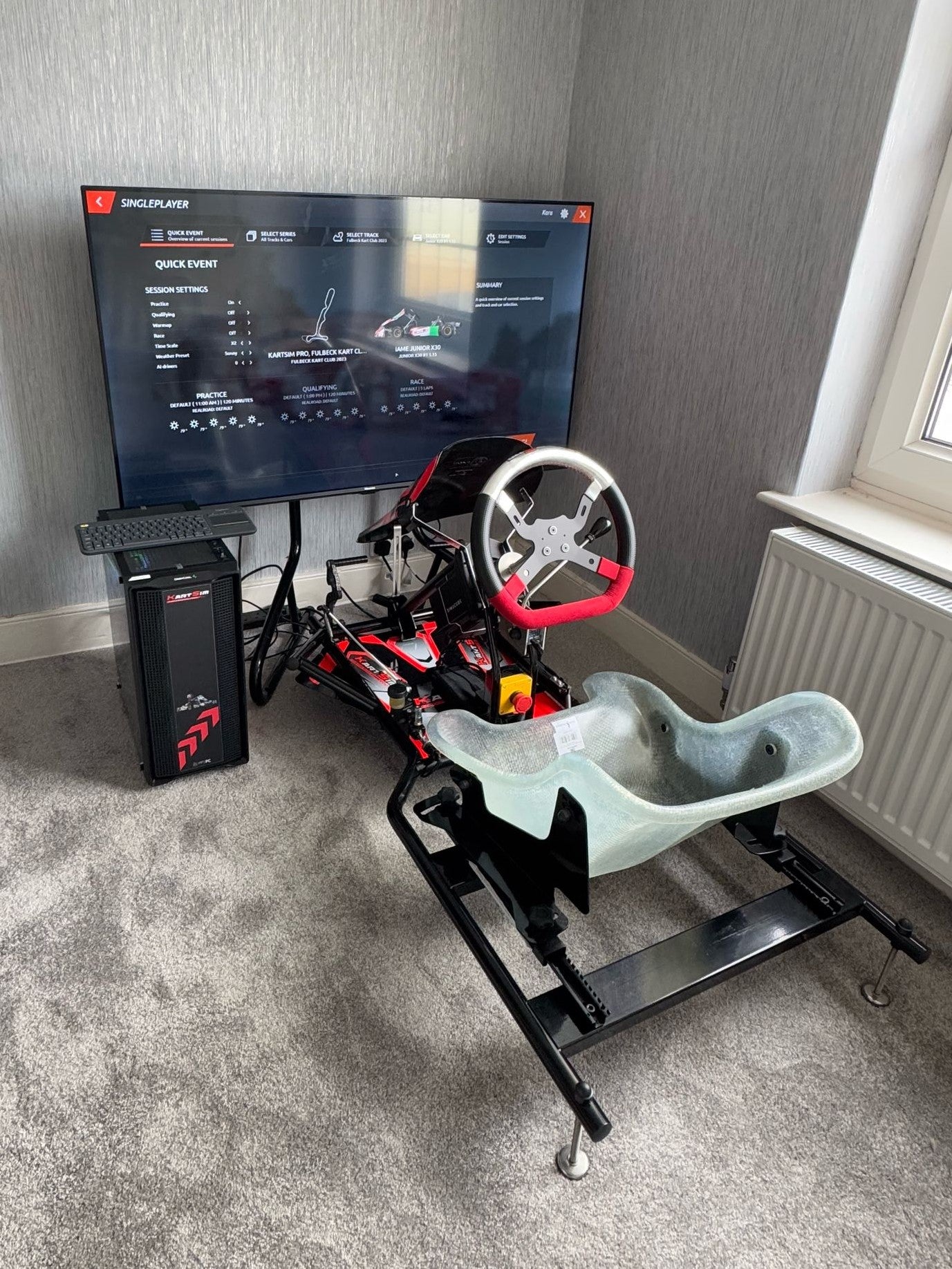 Front view of the KartSim Pro Simulator at home, showing kart chassis, direct drive wheel and adjustable seat setup for high-level karting simulation.