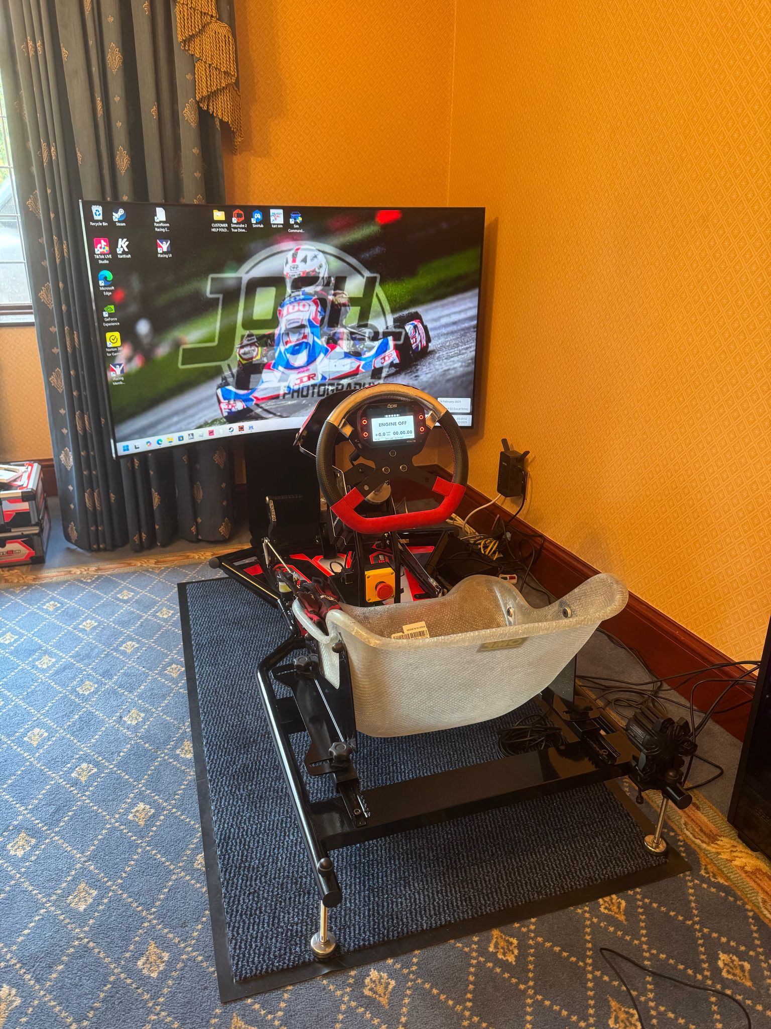 Rear view of a KartSim Pro Simulator set up at home, focusing on the kart chassis and simulation seat.