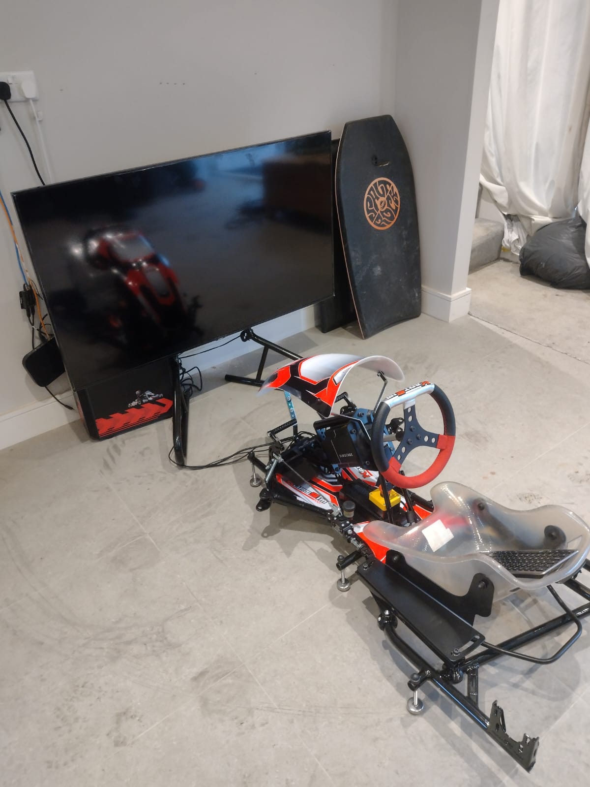 KartSim Pro Simulator photographed from the side in a relaxed home setting, offering a close-up of its realistic karting components.