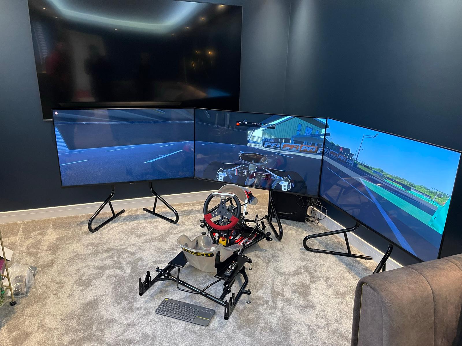 KartSim Pro Simulator surrounded by a triple screen setup in a professional-grade home studio.