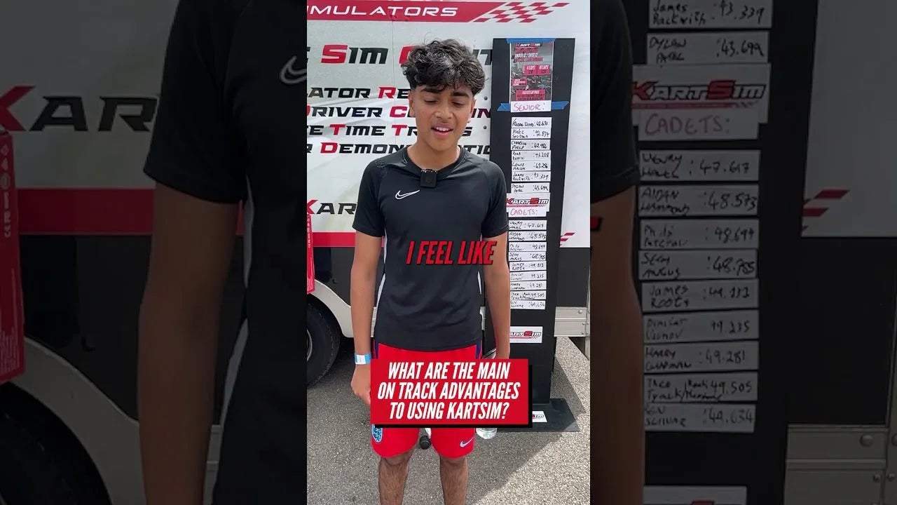 Kart driver discussing KartSim simulator training benefits in front of leaderboard and promotional display.