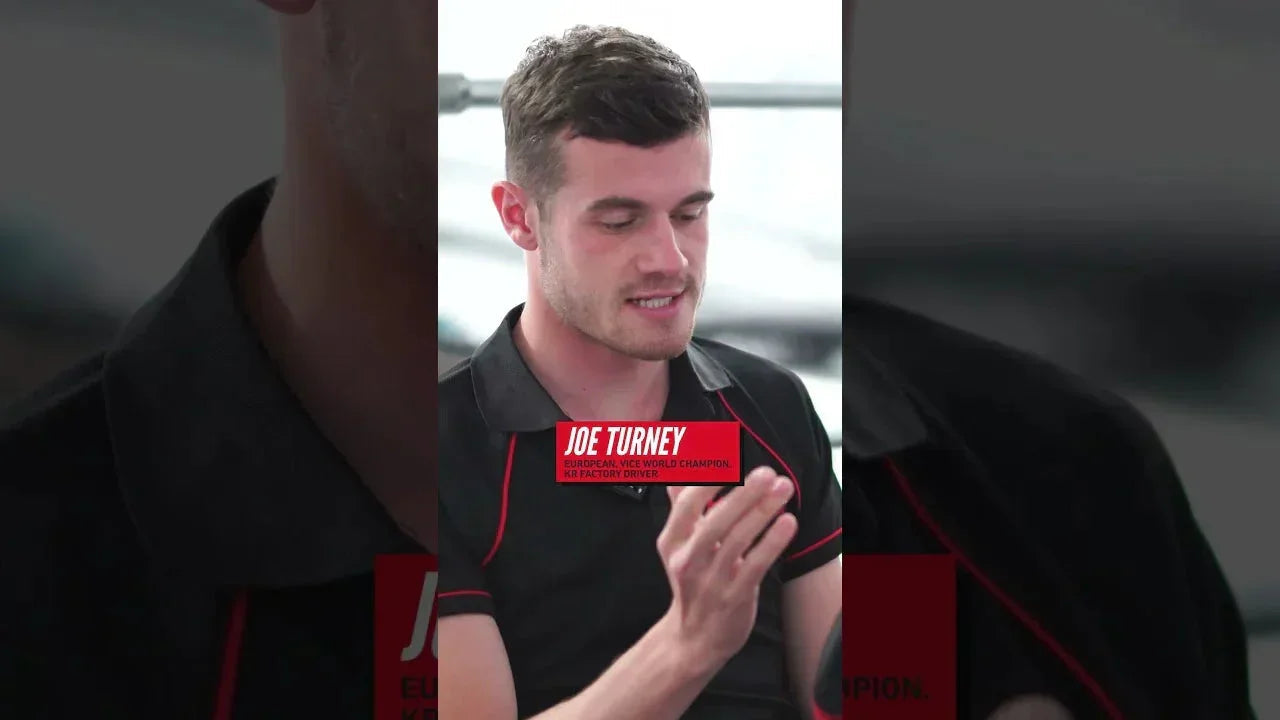 Professional kart driver in discussion, showcasing focused kart driver training environment.