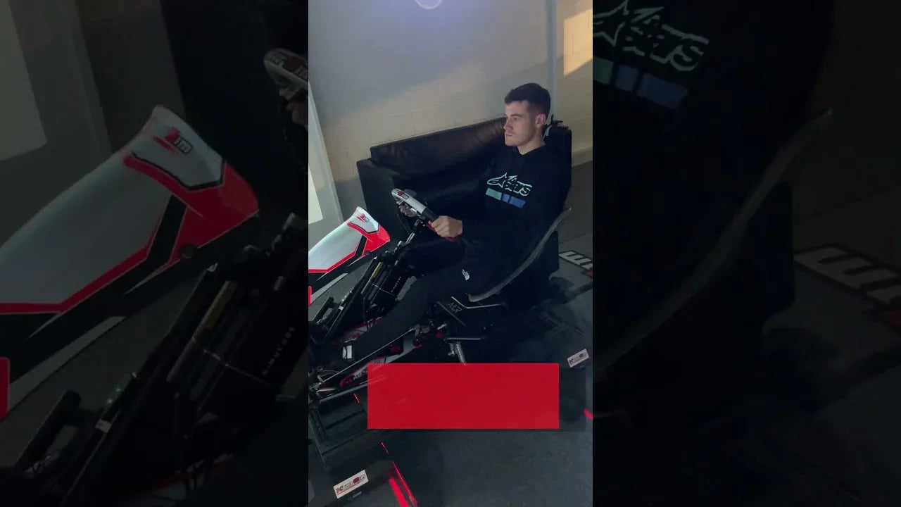 Driver seated in professional kart simulator rig with realistic wheel and pedal setup for kart training