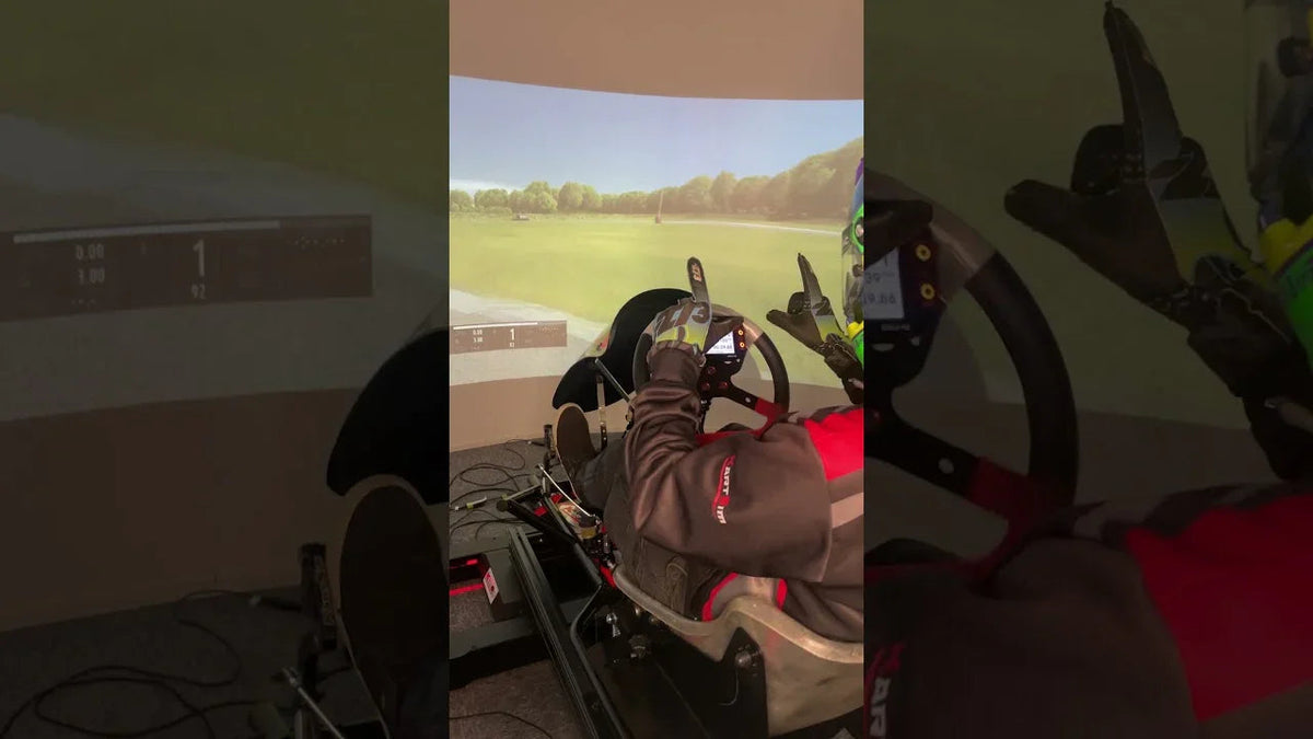 Professional kart driver using kart racing simulator rig with realistic steering wheel and pedals for training