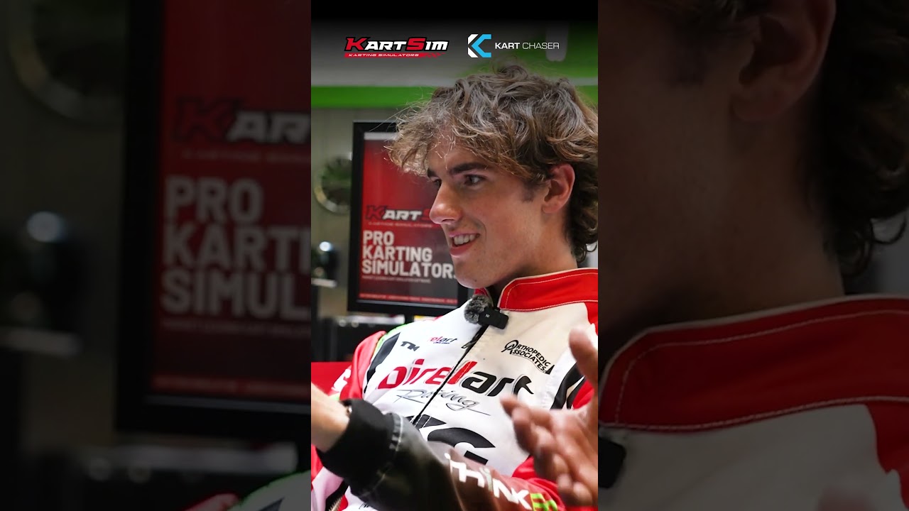 Kart driver in racing suit smiling during professional kart simulator training session with KartSim branding visible