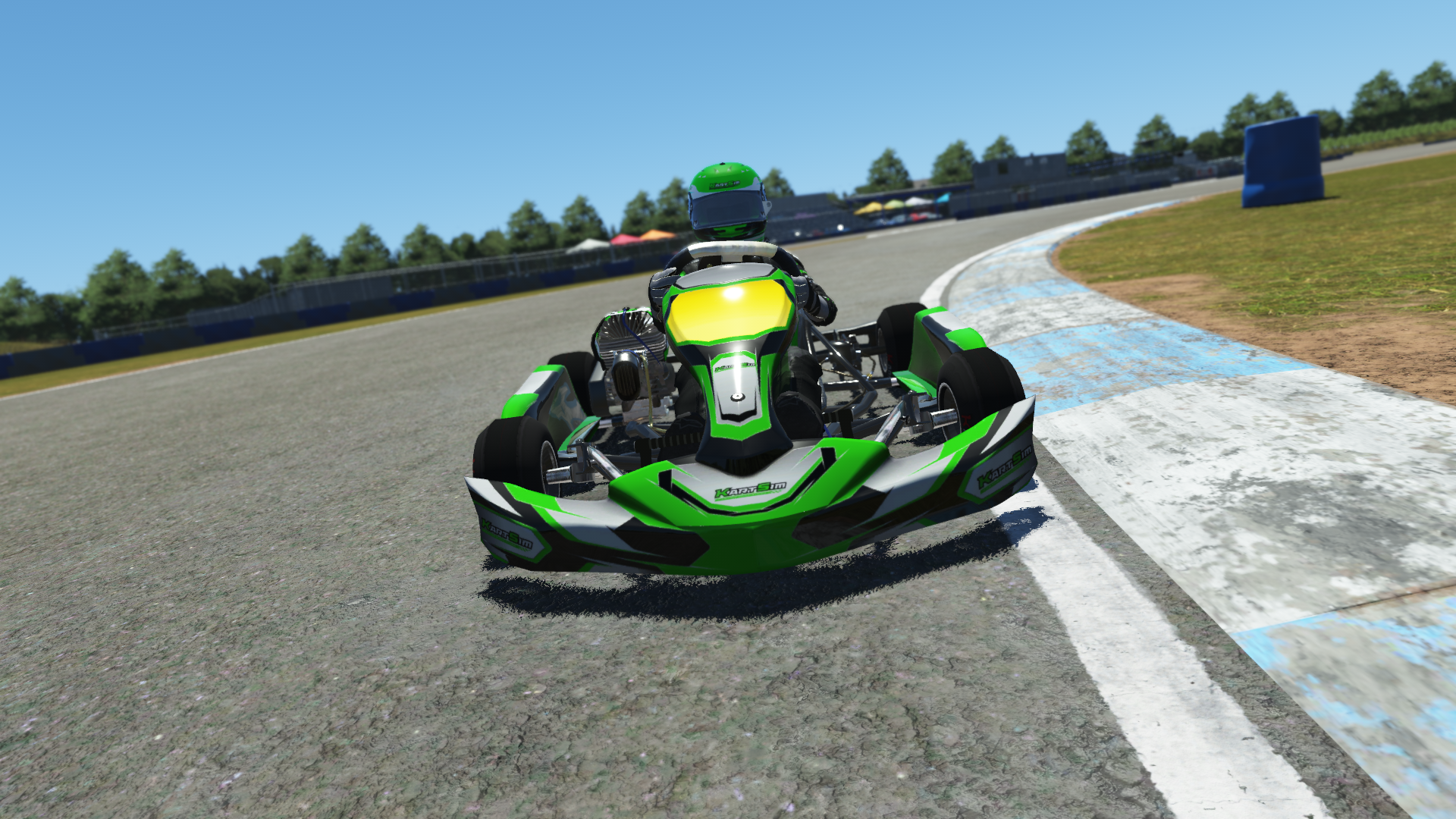 IAME Kid kart driver in green and black racing suit driving on track with forest background