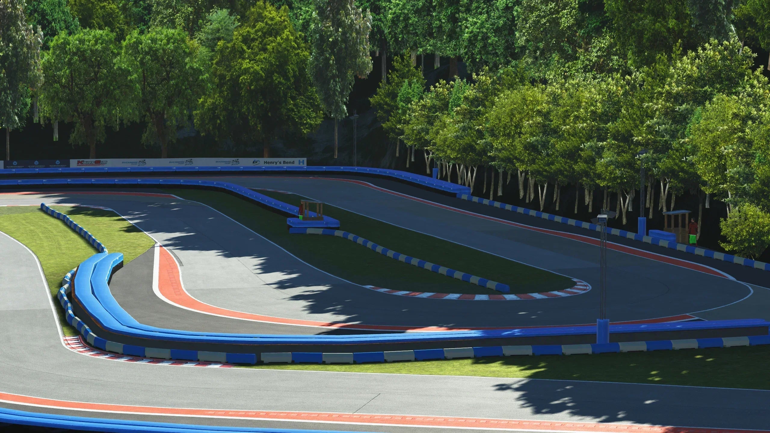 Henry’s Bend in Full Flow – A closer look at one of Buckmore’s signature corners, flanked by tall trees and bright blue barriers, demanding precision and bravery from drivers.