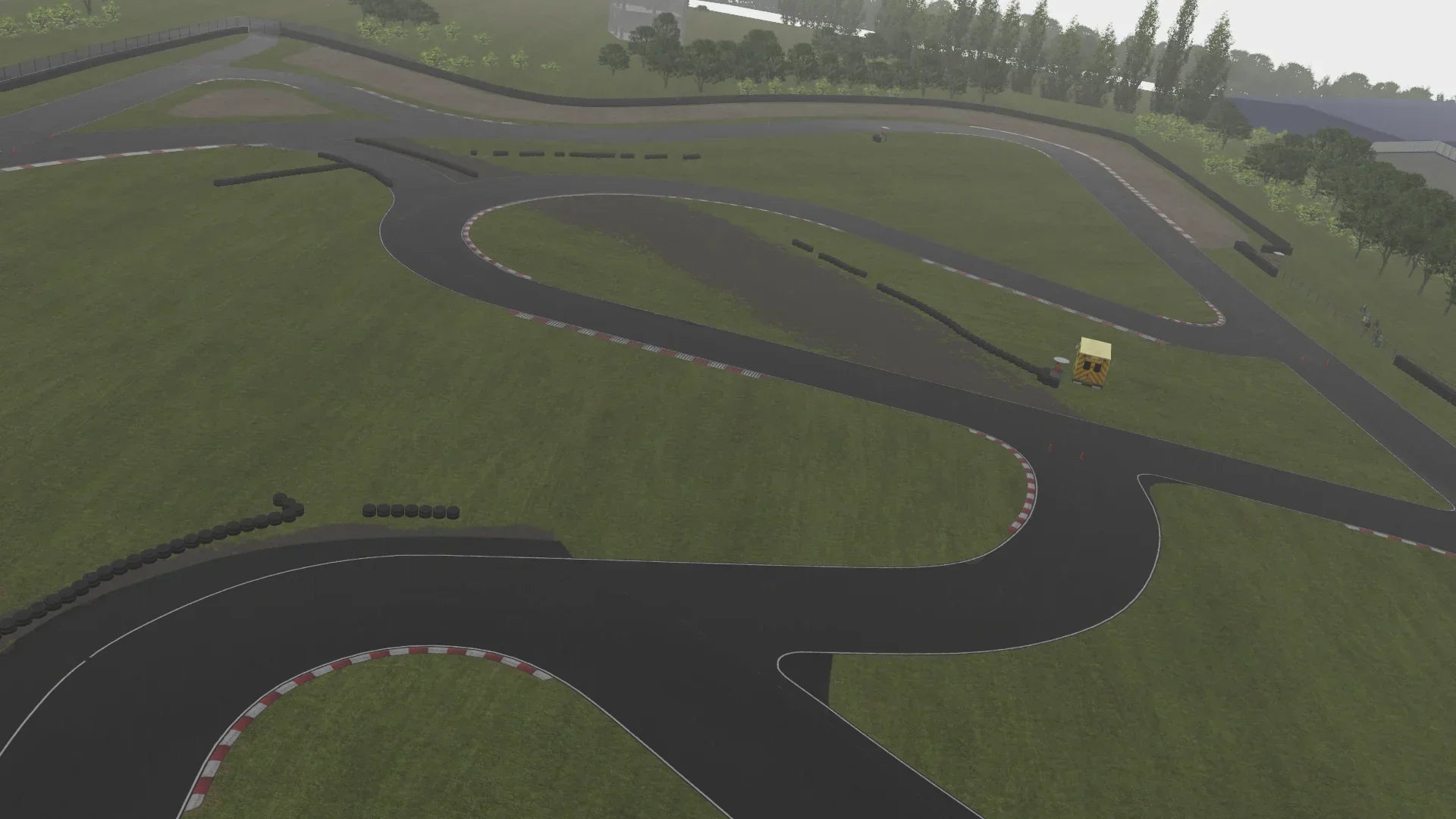 KartSim Nutts Corner Overcast View – Overhead view of the KartSim Nutts Corner track in wet conditions, showing darker tarmac, slick corners, and reduced visibility.