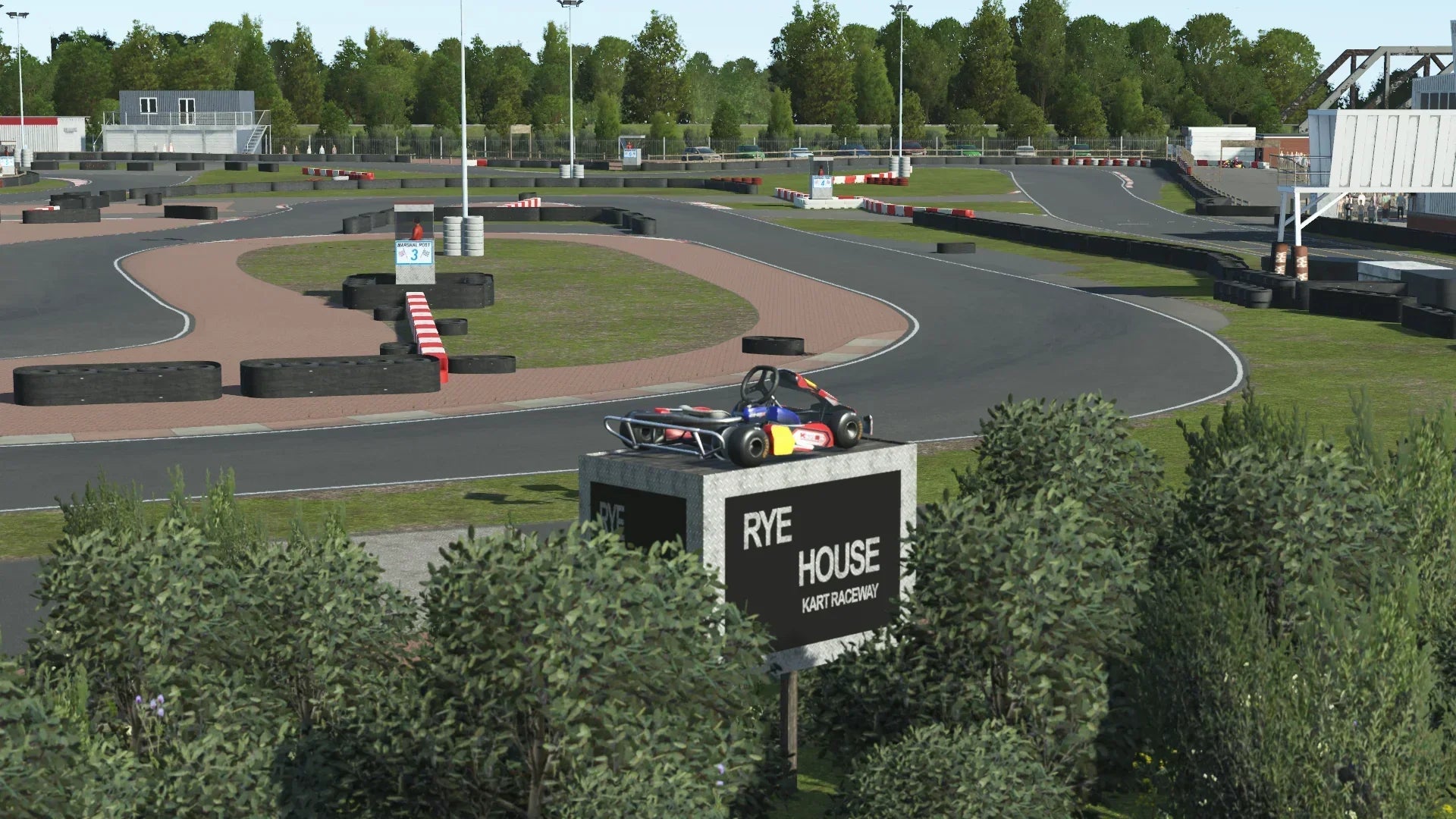 KartSim Rye House track entrance featuring the iconic kart display on a plinth, surrounded by lush greenery and a winding circuit backdrop.