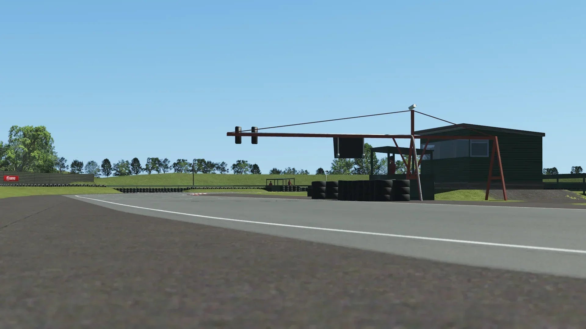 Ground-level view of Shenington's start/finish straight with timing gantry and surrounding scenery, rendered in KartSim Pro.