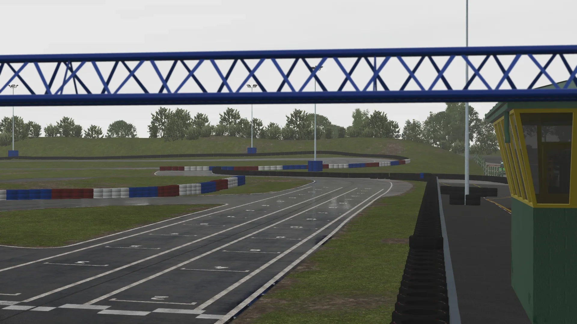 Detailed paddock area and track entry point at Warden Law circuit, highlighting buildings, start line, and pit lane in the simulation environm