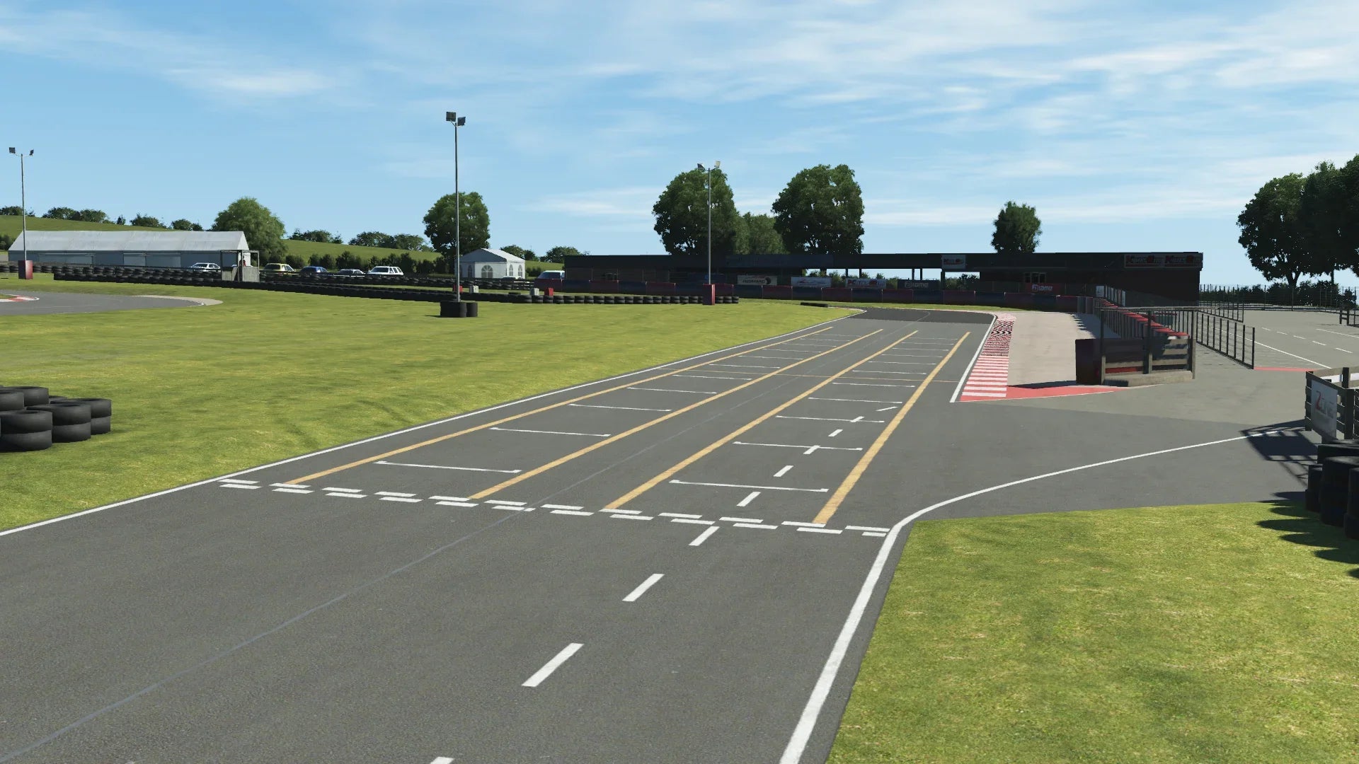 KartSim Whilton Mill start/finish straight – The main straight and grid area at Whilton Mill, complete with pit lane entry and trackside barriers, rendered in KartSim.