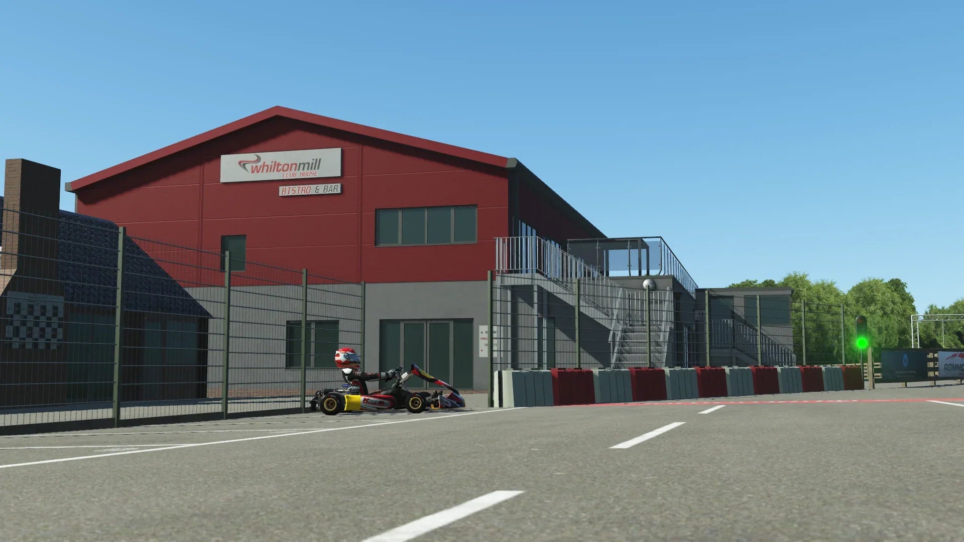 KartSim Whilton Mill clubhouse and pit lane – Close-up of the Whilton Mill clubhouse with a kart leaving the pits, recreated in KartSim’s high-quality visuals.