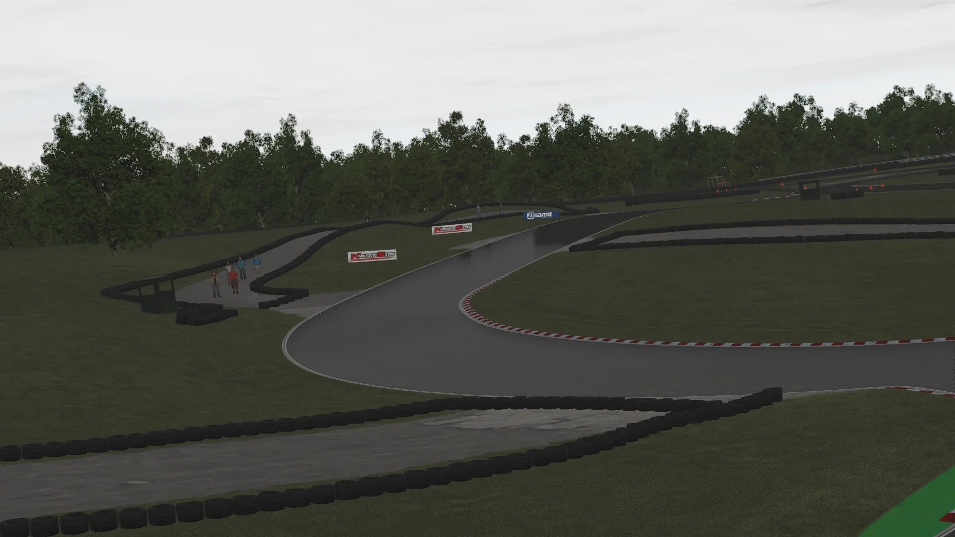 Curving section under grey skies – A long, flowing corner bordered by tyre walls and grass, perfect for practicing smooth racing lines.