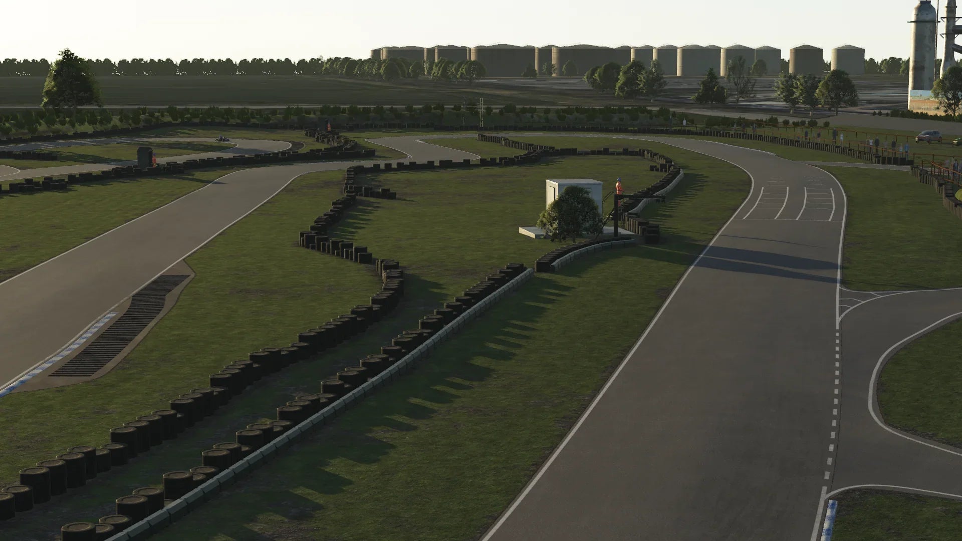 Evening sunlight over Hooton Park in KartSim – Long shadows stretch across the smooth tarmac as the track curves gently past the start-finish line.