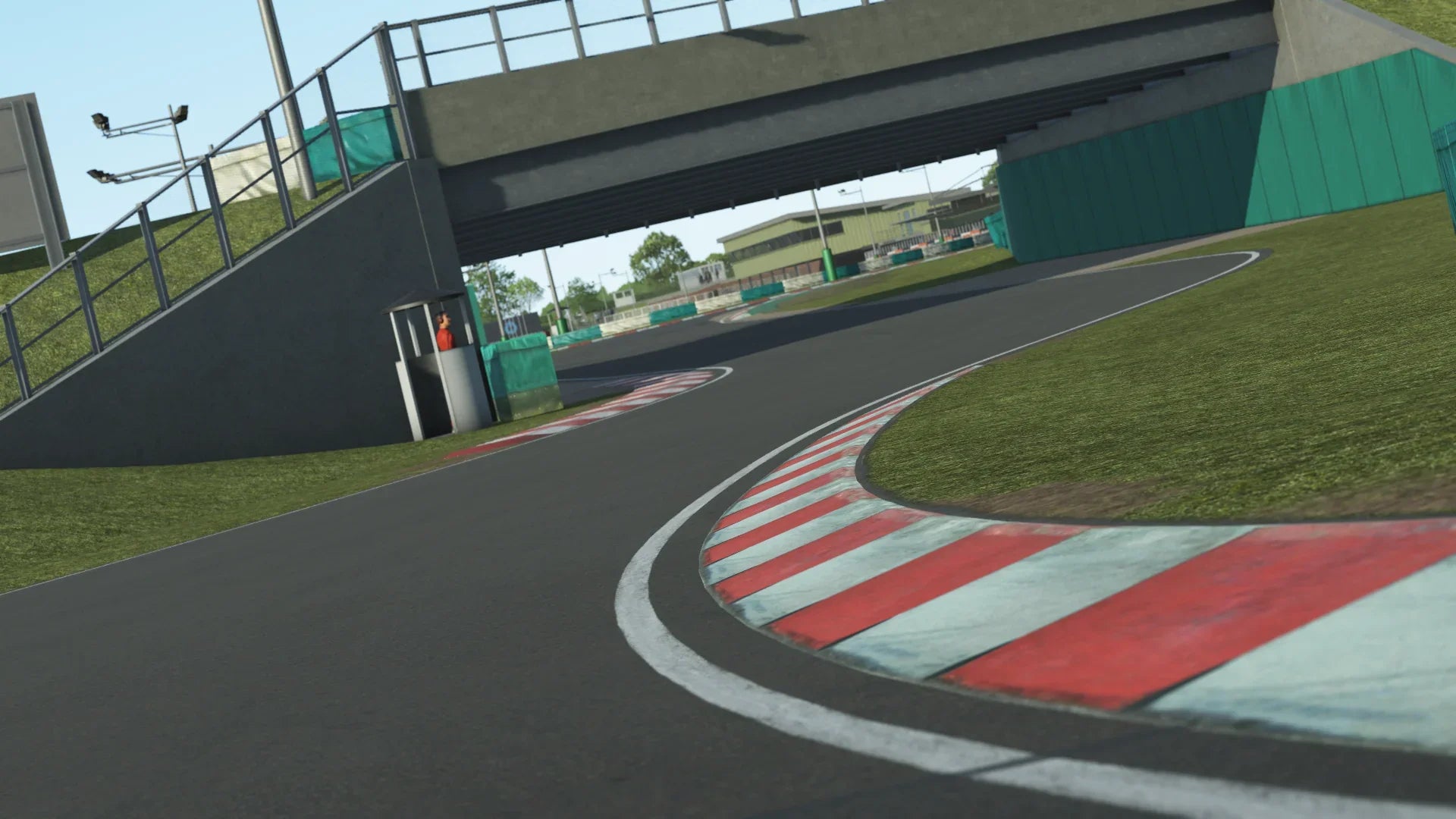 A close-up view of the sweeping right-hander under the famous bridge at PFI International recreated in KartSim, showing detailed kerbs and trackside scenery.