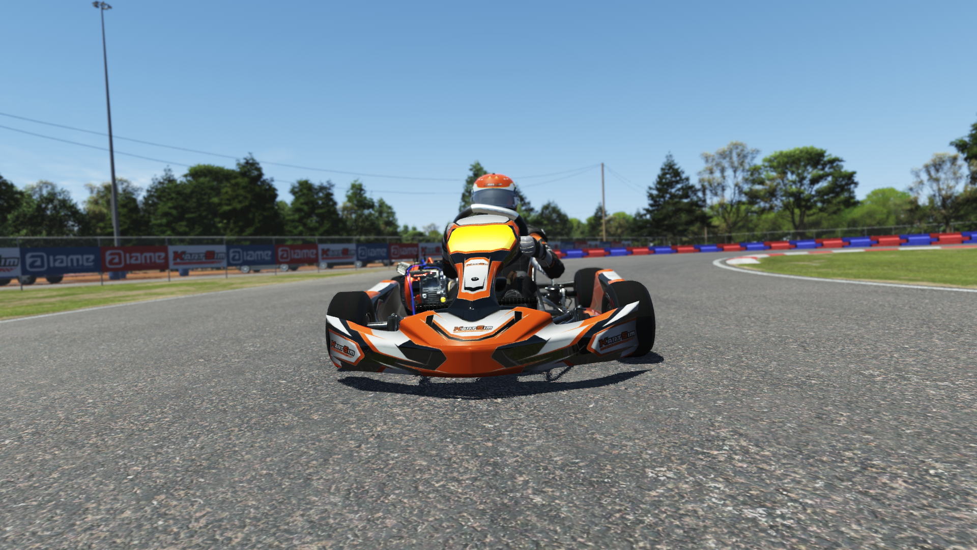 Briggs 206 Cadet 003 kart with blue and white design shown on KartSim software racing on kart track with tire barriers