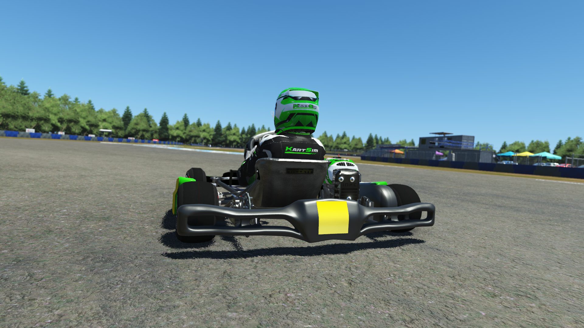 IAME Kid Kart 000 model in green and white livery on karting track with grass and trees in background
