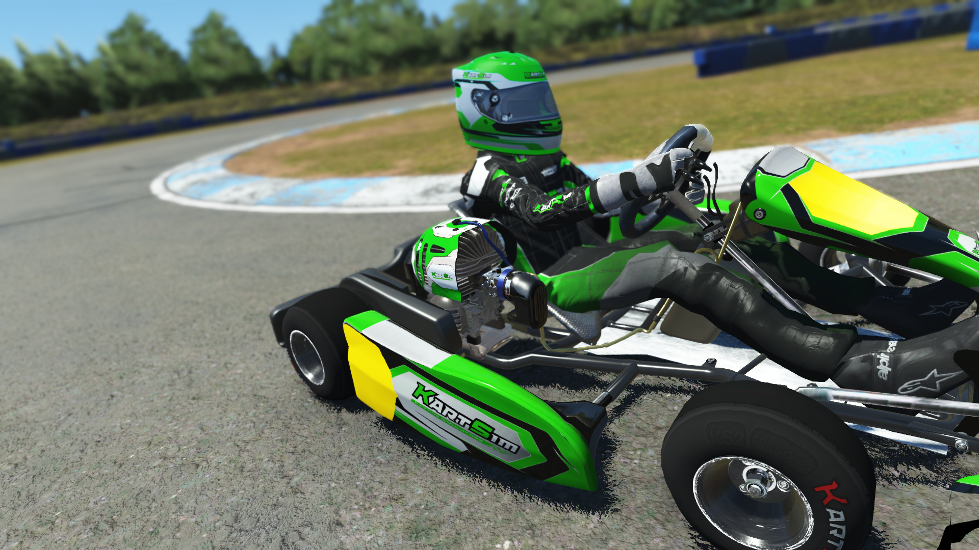 IAME Kid Kart 001 model in green and black livery on karting track with grass and trees in background