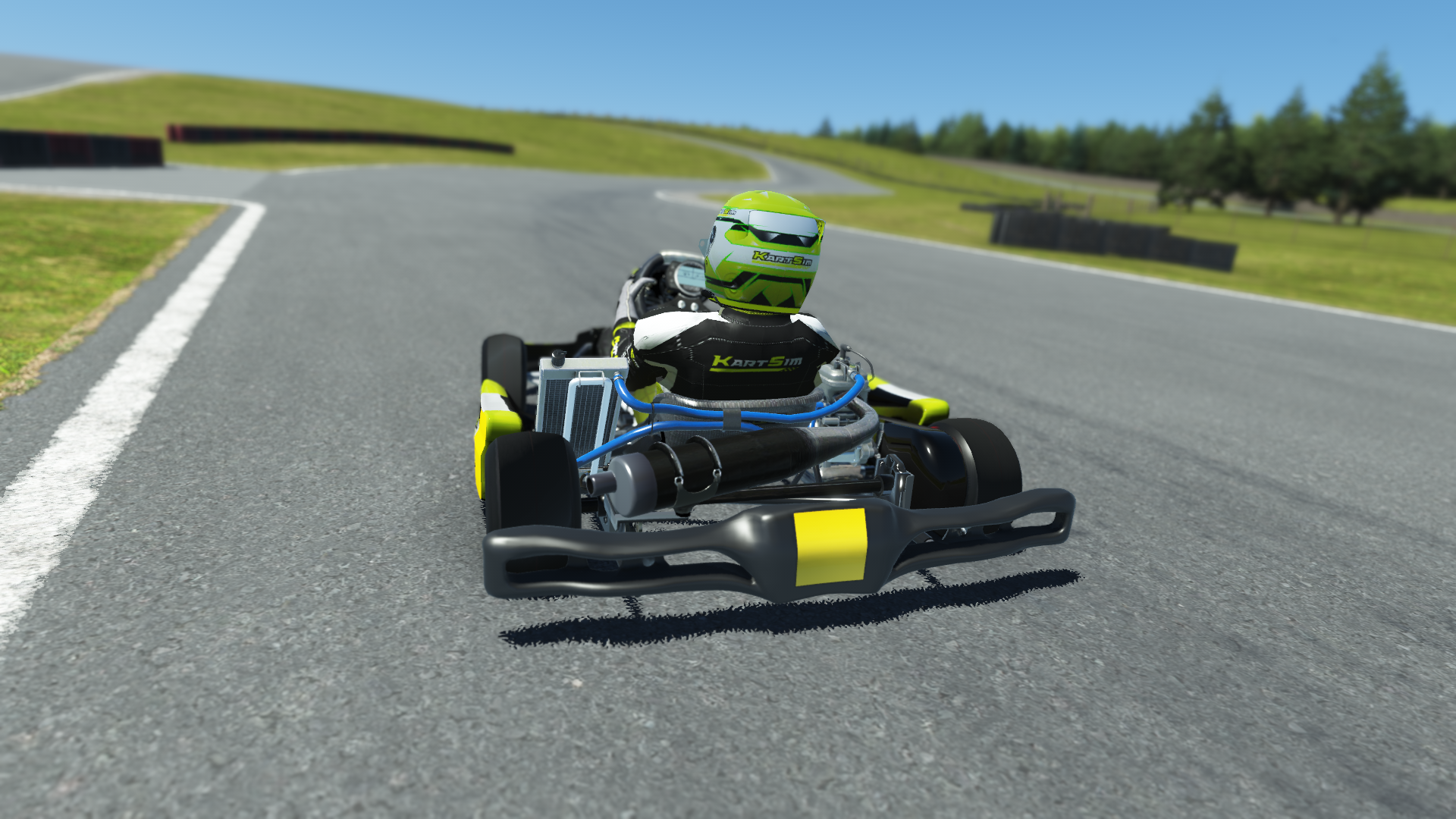 IAME Micro Swift 000 kart with blue and yellow colors on karting track with tire barriers and grass