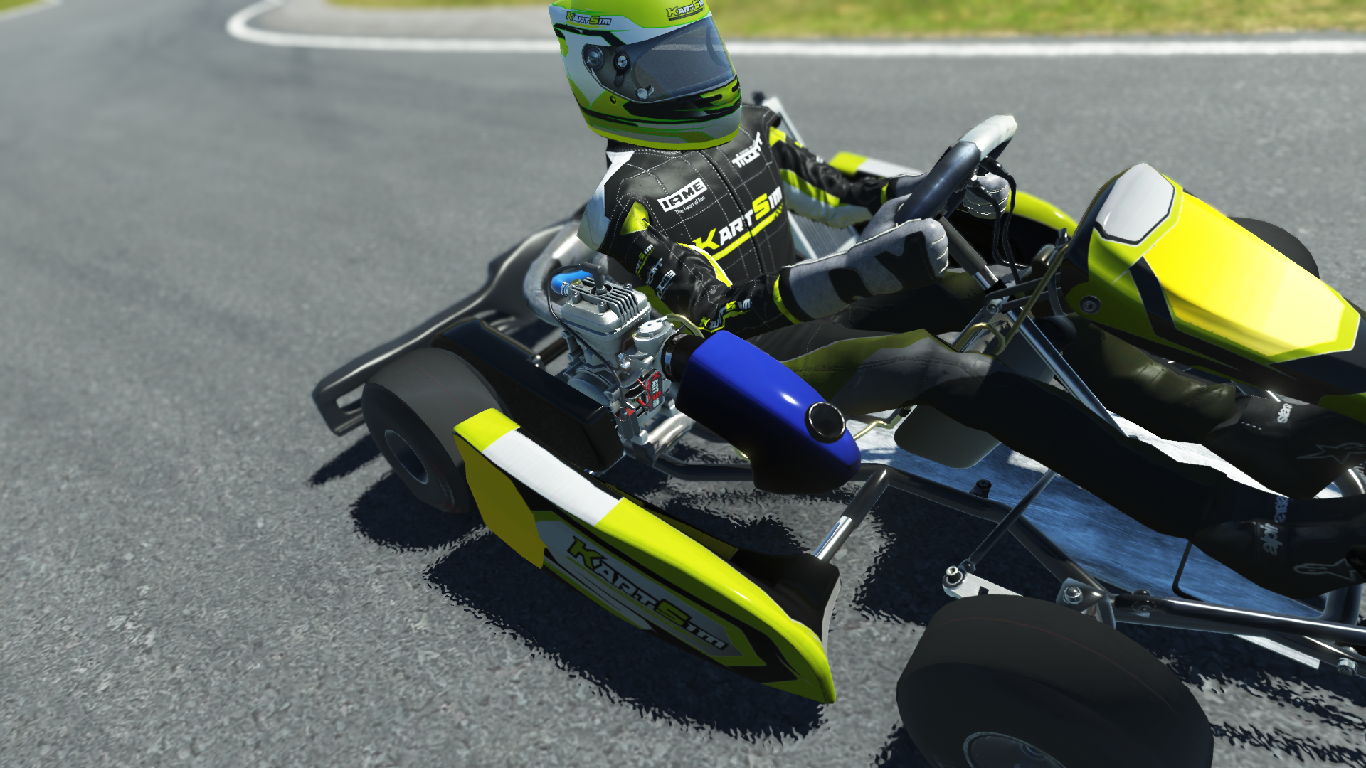 IAME Micro Swift 001 kart with blue and yellow design racing on kart track with tire barriers and grass