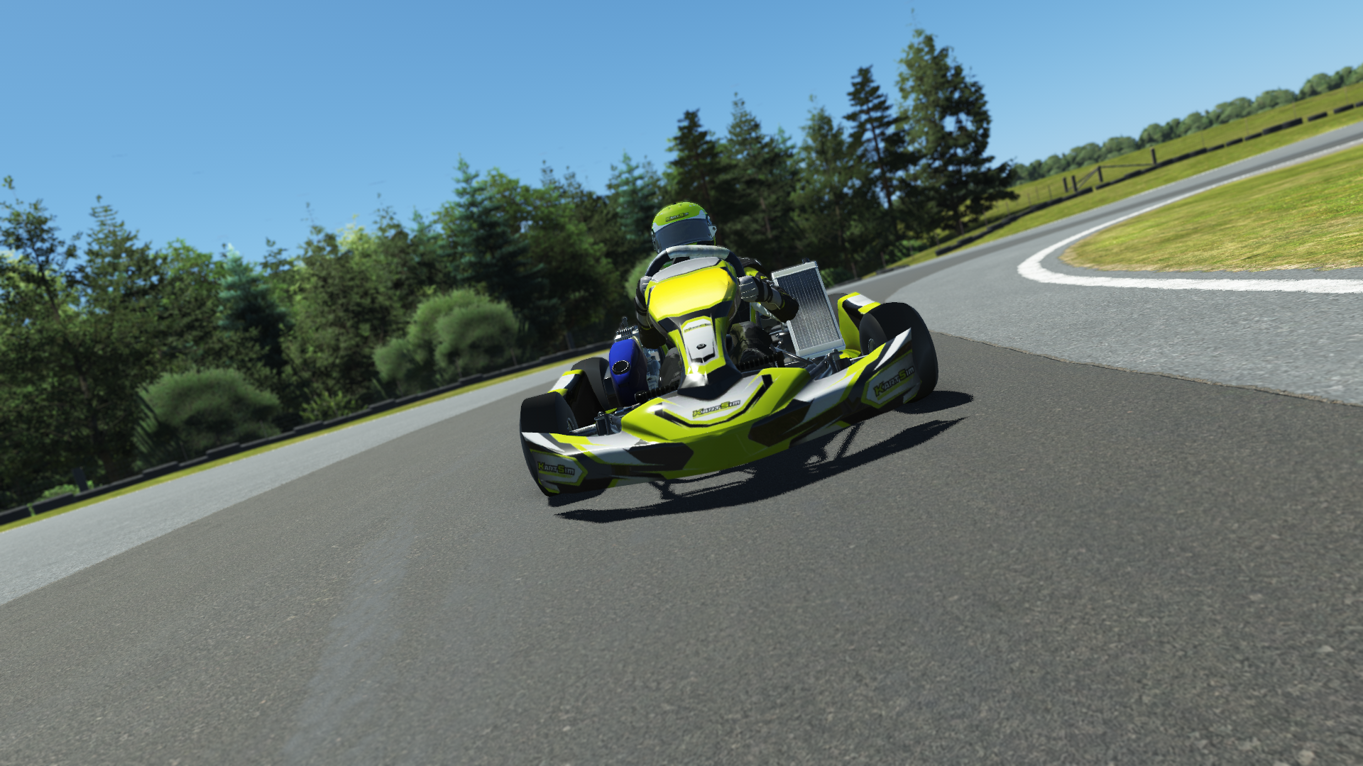 IAME Micro Swift 002 kart with blue and yellow design on karting track with tire barriers and grass