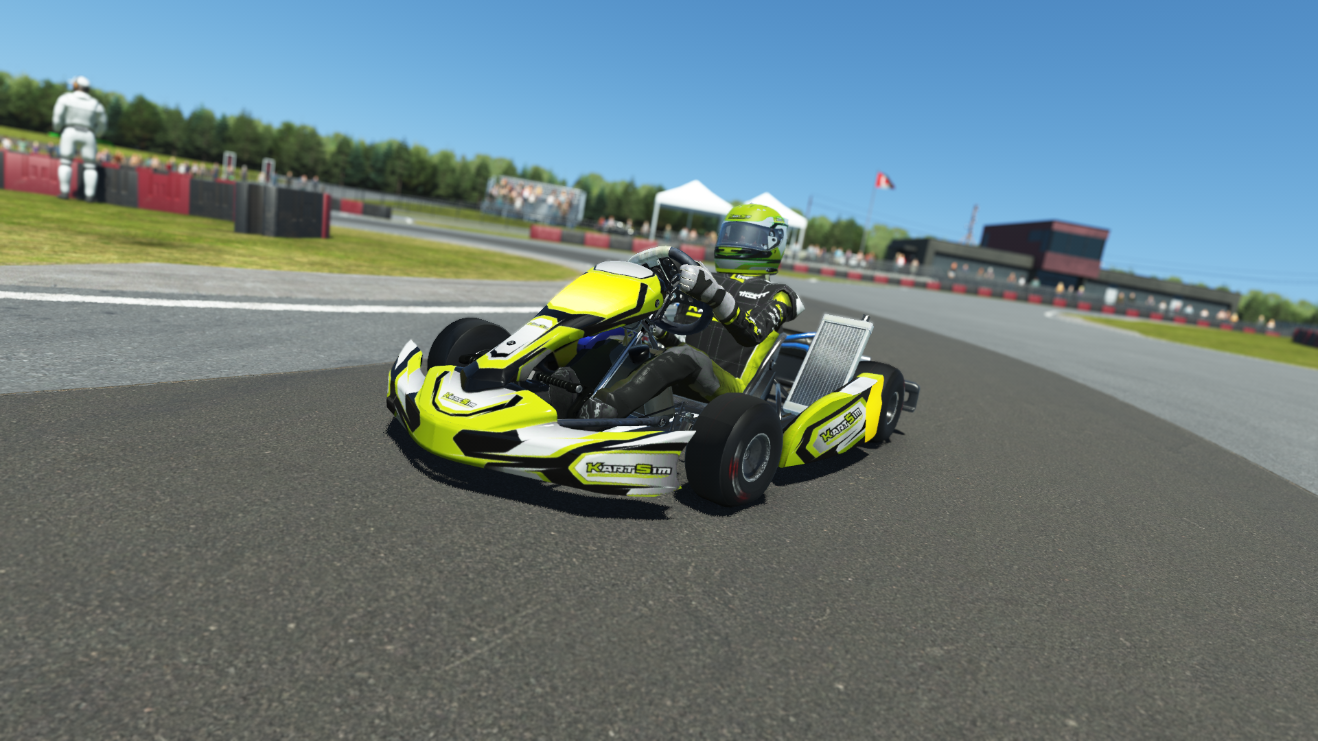 IAME Micro Swift 004 kart in blue and yellow livery on a karting circuit with grass and tire barriers