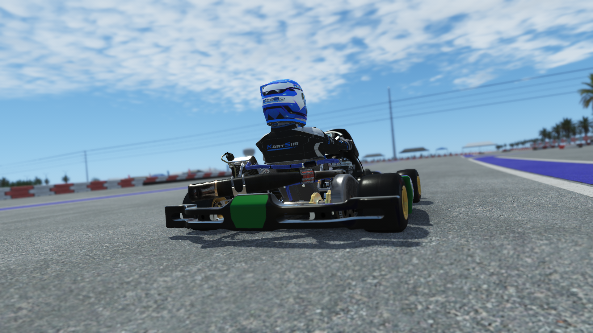 IAME X30 Junior US 004 kart with blue, white, and yellow design shown on KartSim software racing on kart track with tire barriers