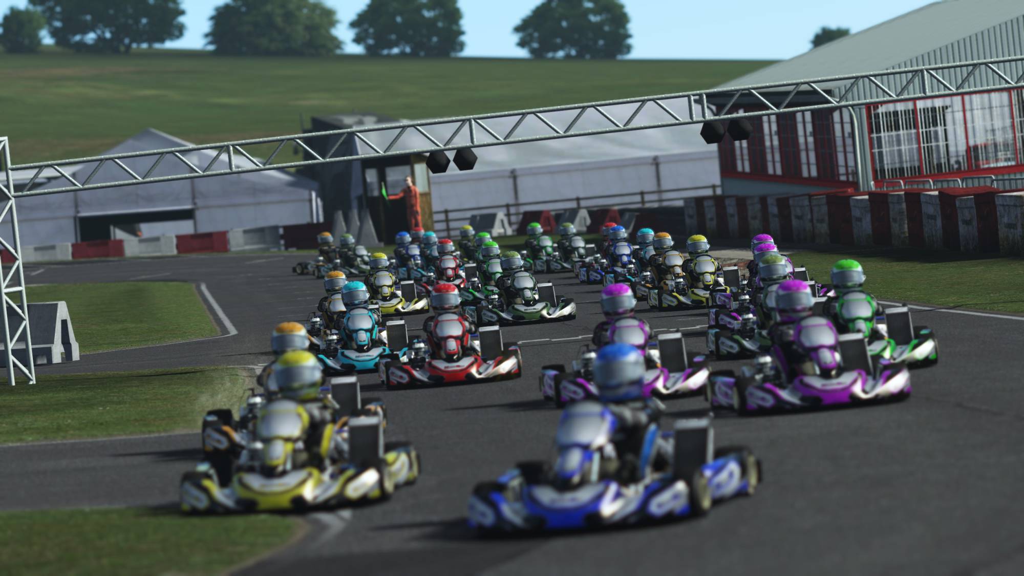 Large grid of racing karts at the starting line during a KartSim esports event on a virtual outdoor circuit