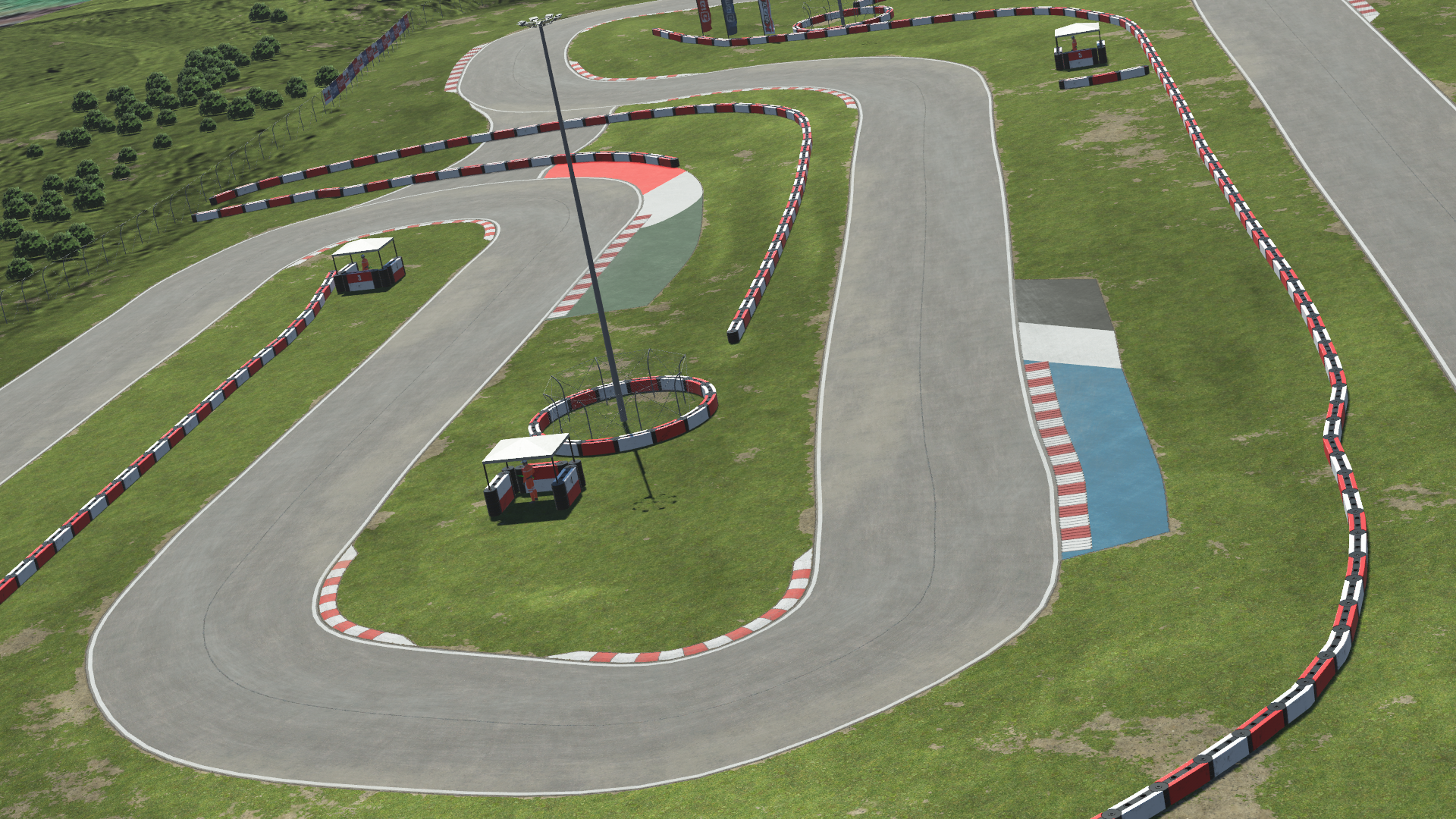 Aerial view of Sarno Racing Circuit with sharp turns and pit buildings, shown in KartSim kart racing simulation software