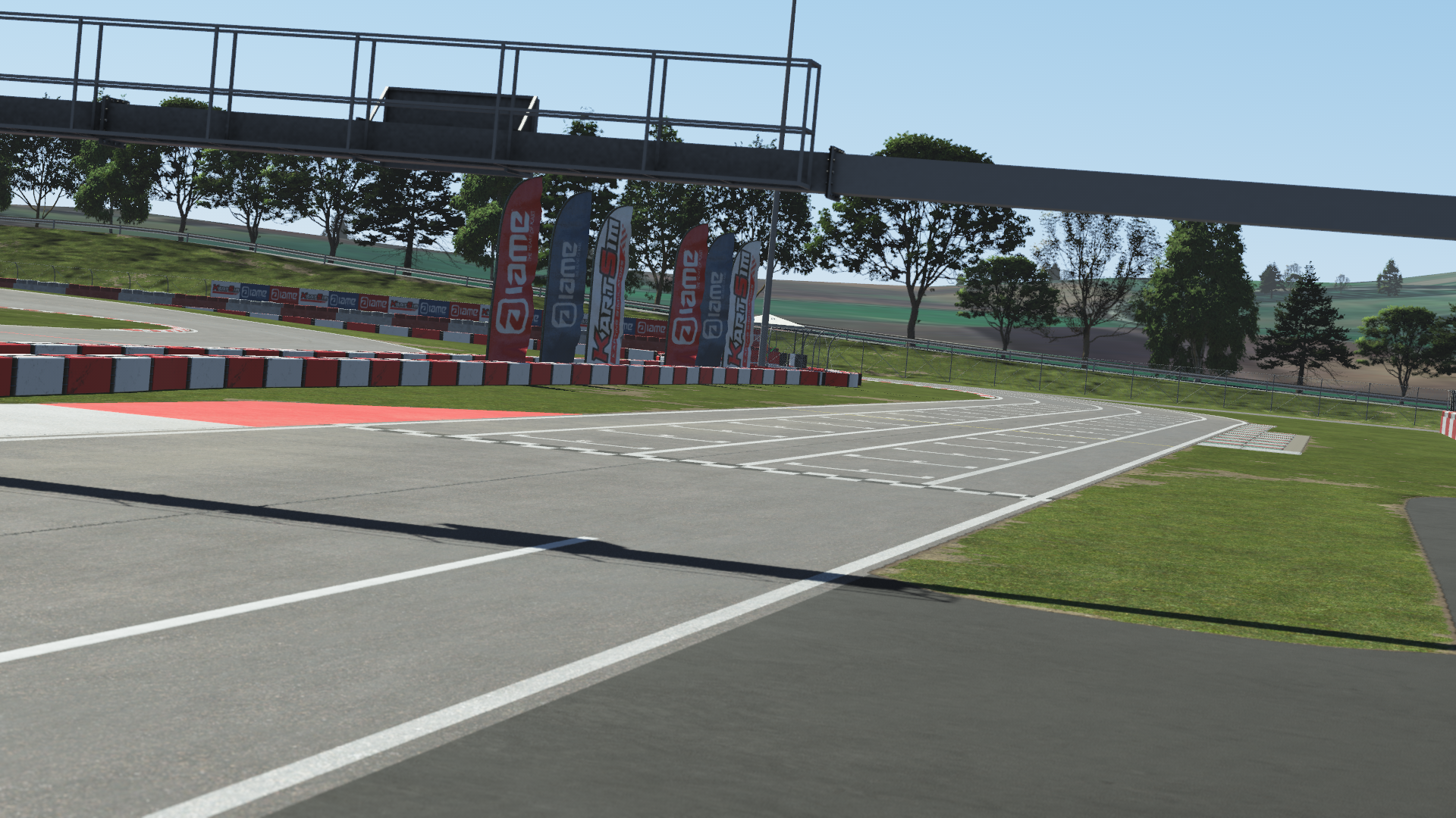 Start-finish line and pit lane of Viterbo Circuit in KartSim racing simulation software, featuring flags and green surroundings