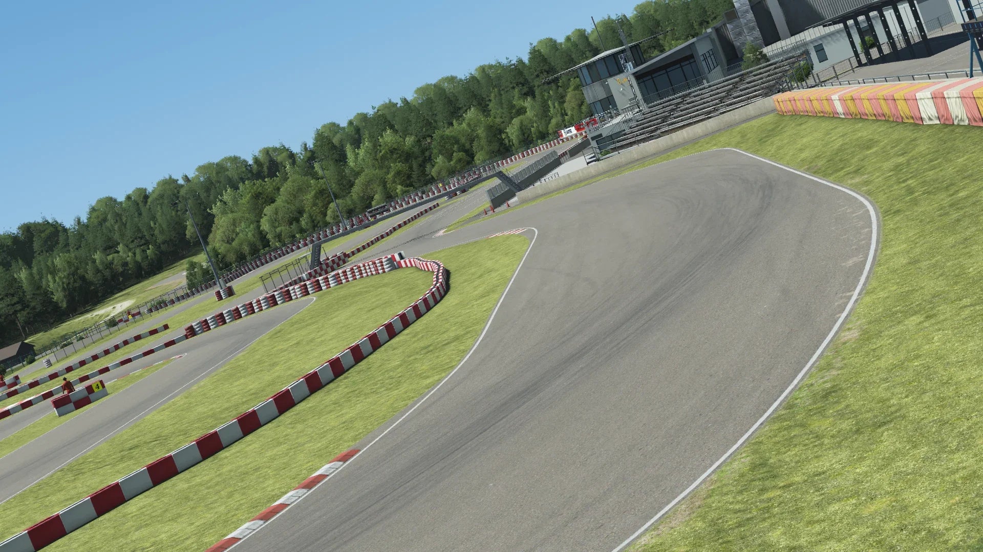 Angled in-simulation view of the Wackersdorf karting circuit in KartSim software, showing the asphalt racing line with red-white kerbs, grass run-off areas, spectator stands, and surrounding forest under a clear blue sky.
