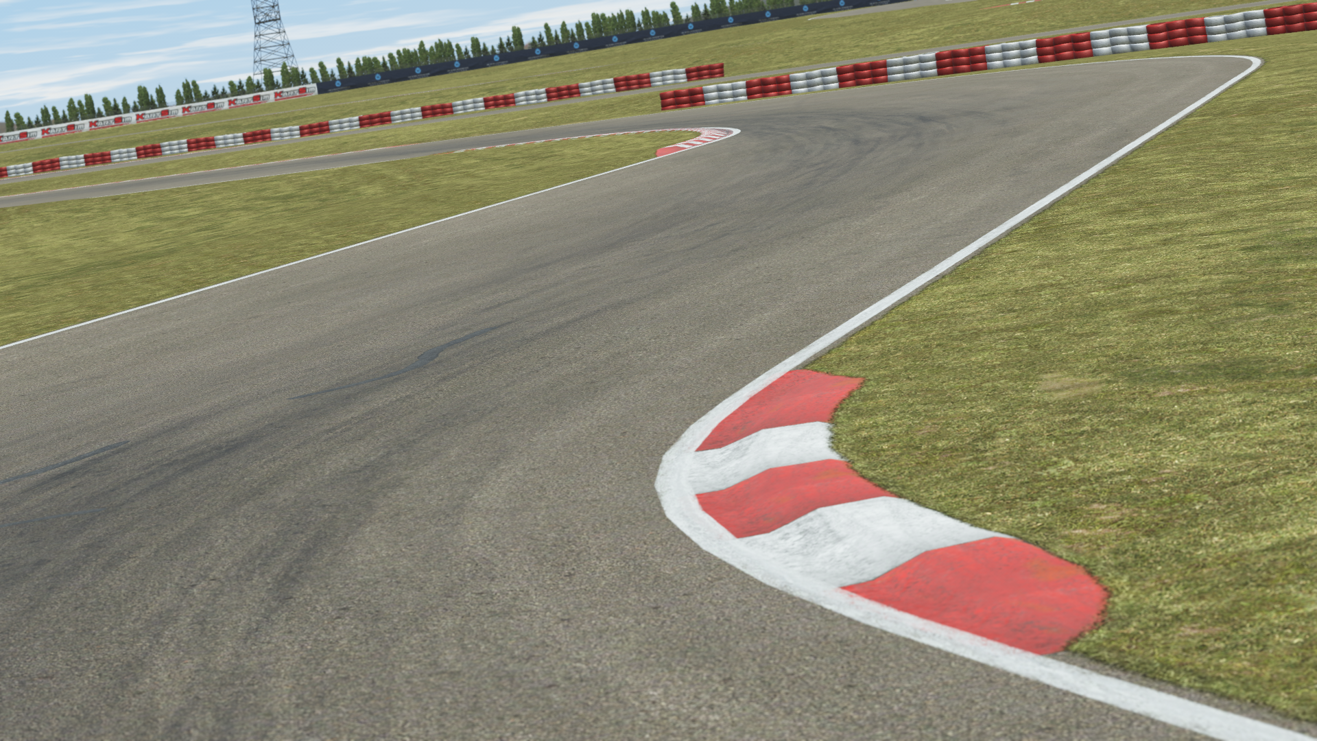 Curved section of Zuera kart racing track with red and white barriers, detailed asphalt and grassy edges, shown in KartSim kart racing simulation software