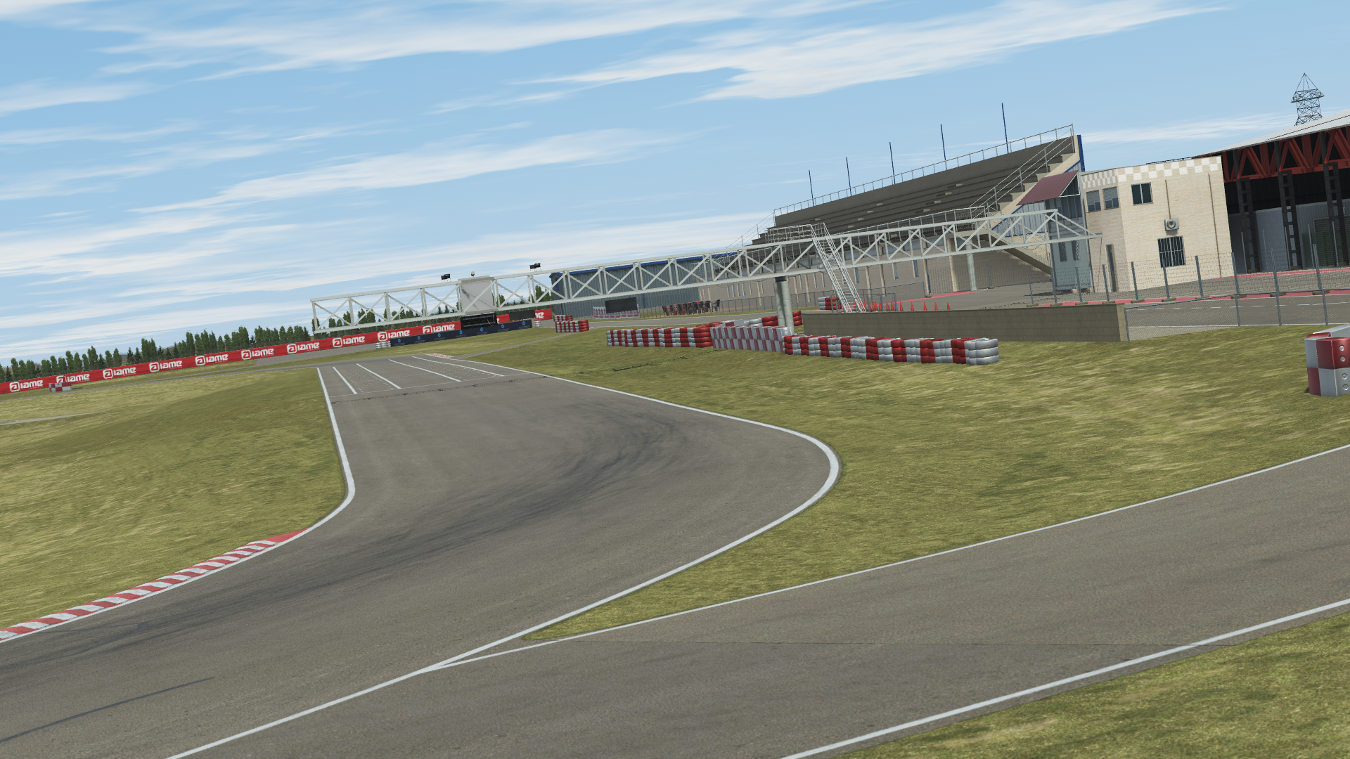 The image features a race track surrounded by lush grass under a clear blue sky. The scene showcases the track and viewing area, emphasizing an outdoor racing environment. This vibrant setting is perfect for motorsports enthusiasts and outdoor events.
