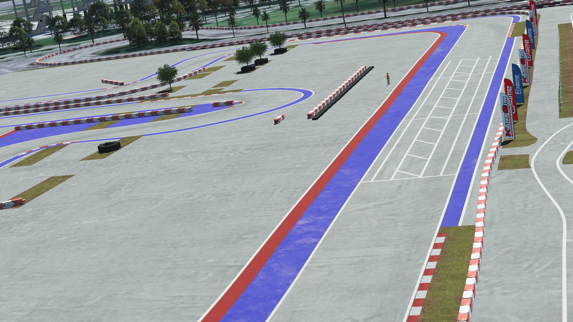 Modern karting track with painted red and blue runoff zones, barriers, and palm trees in the background