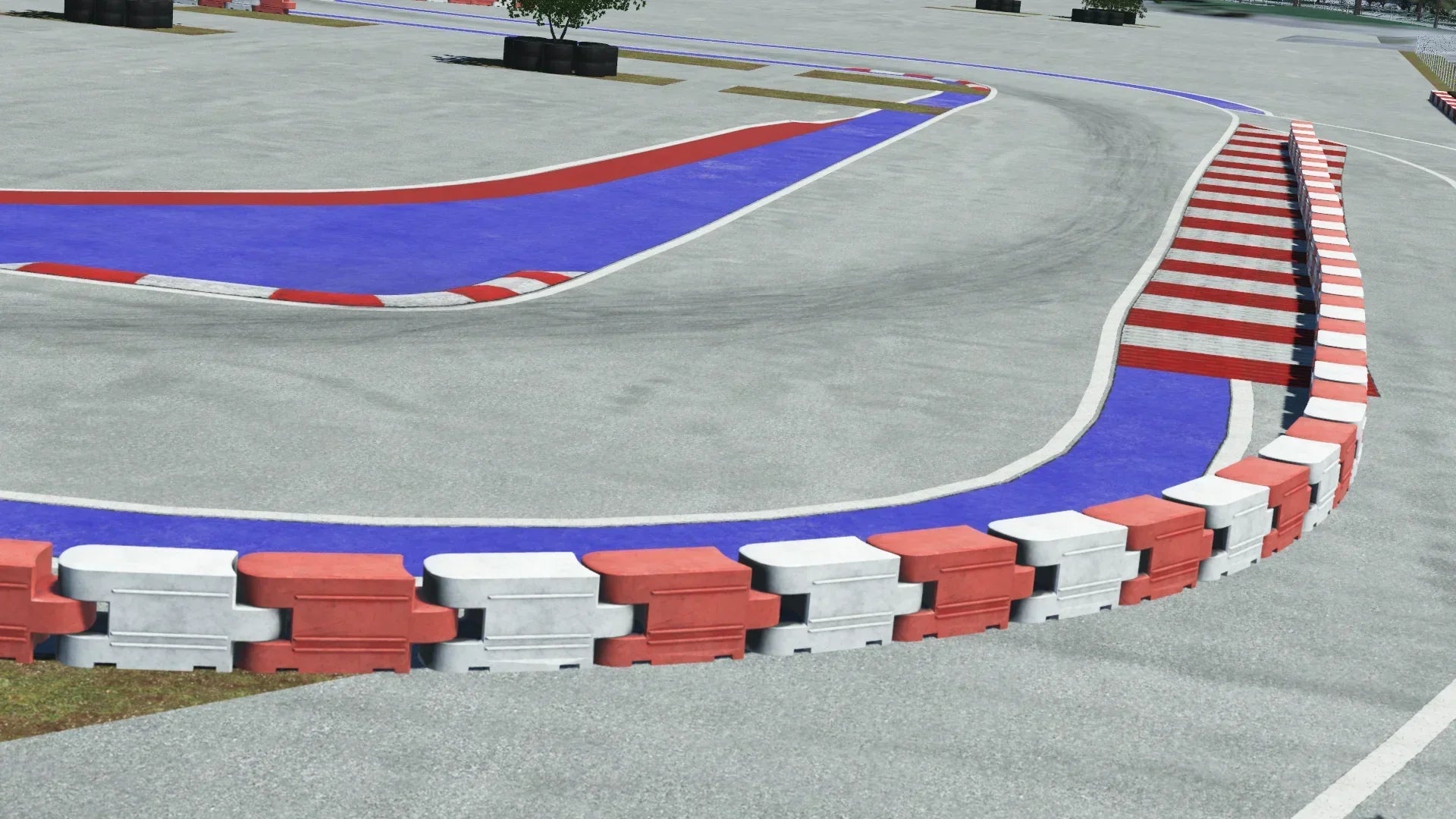 Urban race track section with red, white, and blue curbs and barriers