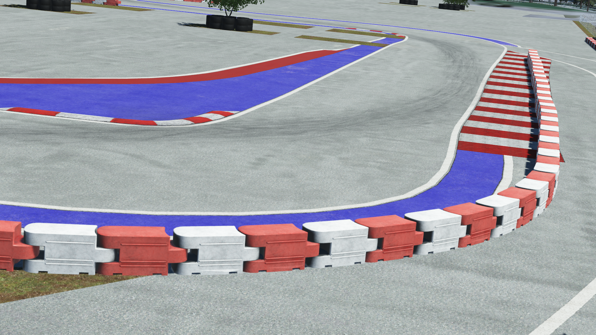 Urban race track section with red, white, and blue curbs and barriers
