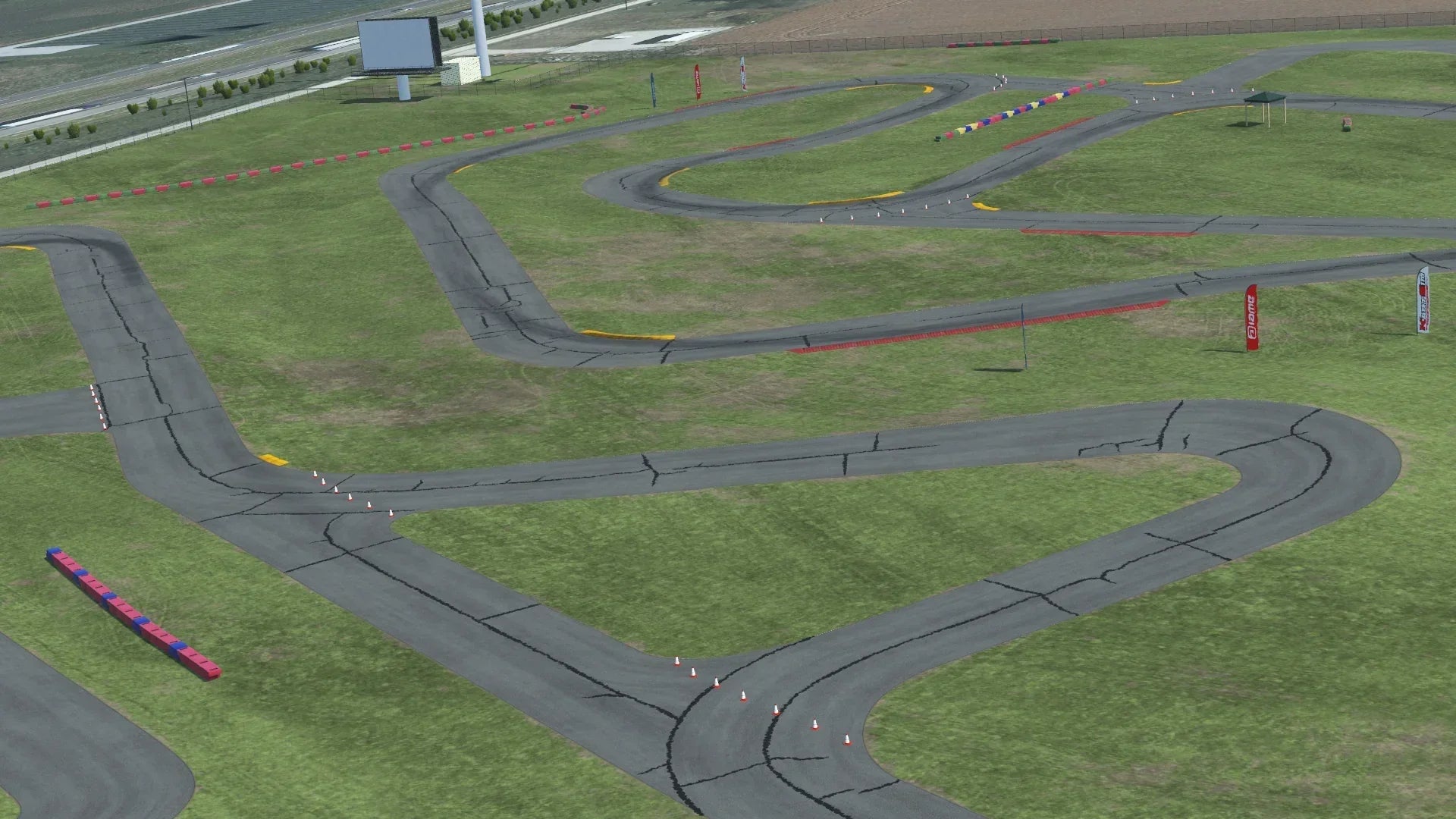 Overhead view of New Castle karting circuit with asphalt track, grassy infield, cones, and safety barriers