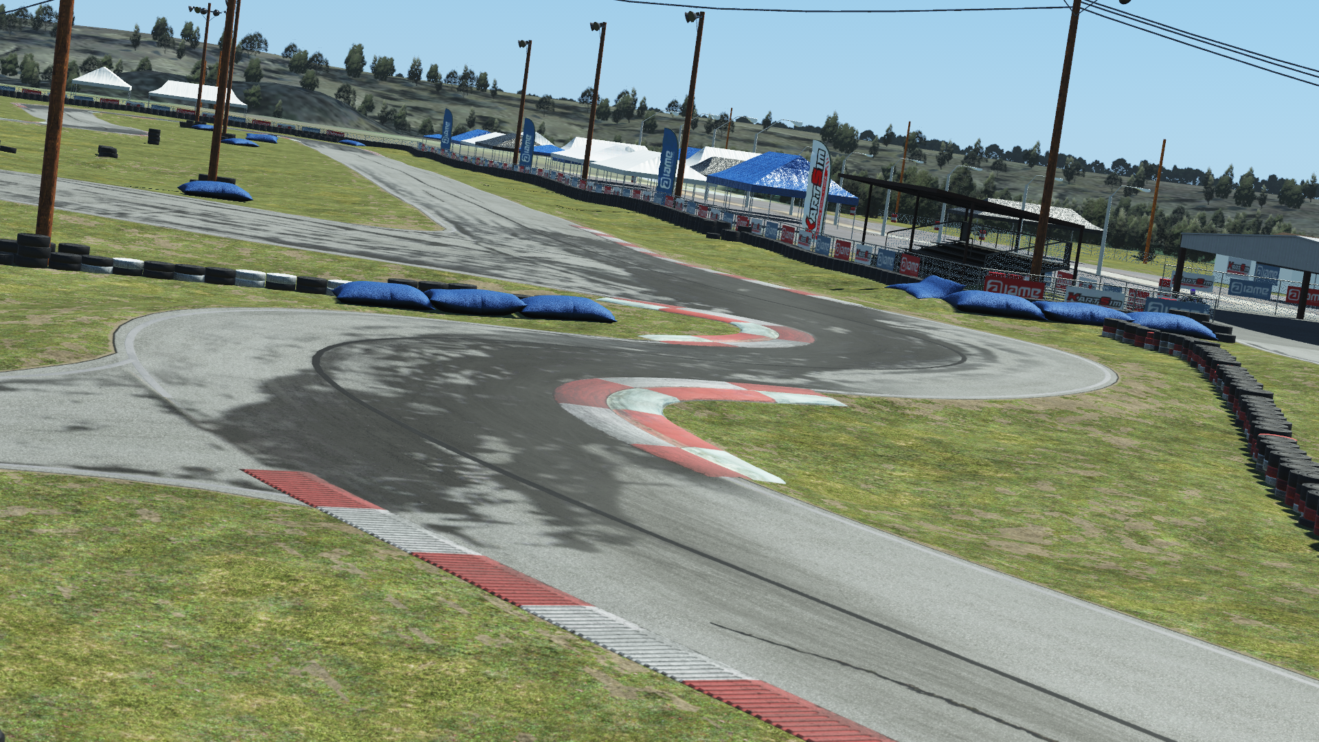 North Texas go-kart track featuring red and white curbs, tire barriers, and shaded turns under a clear sky