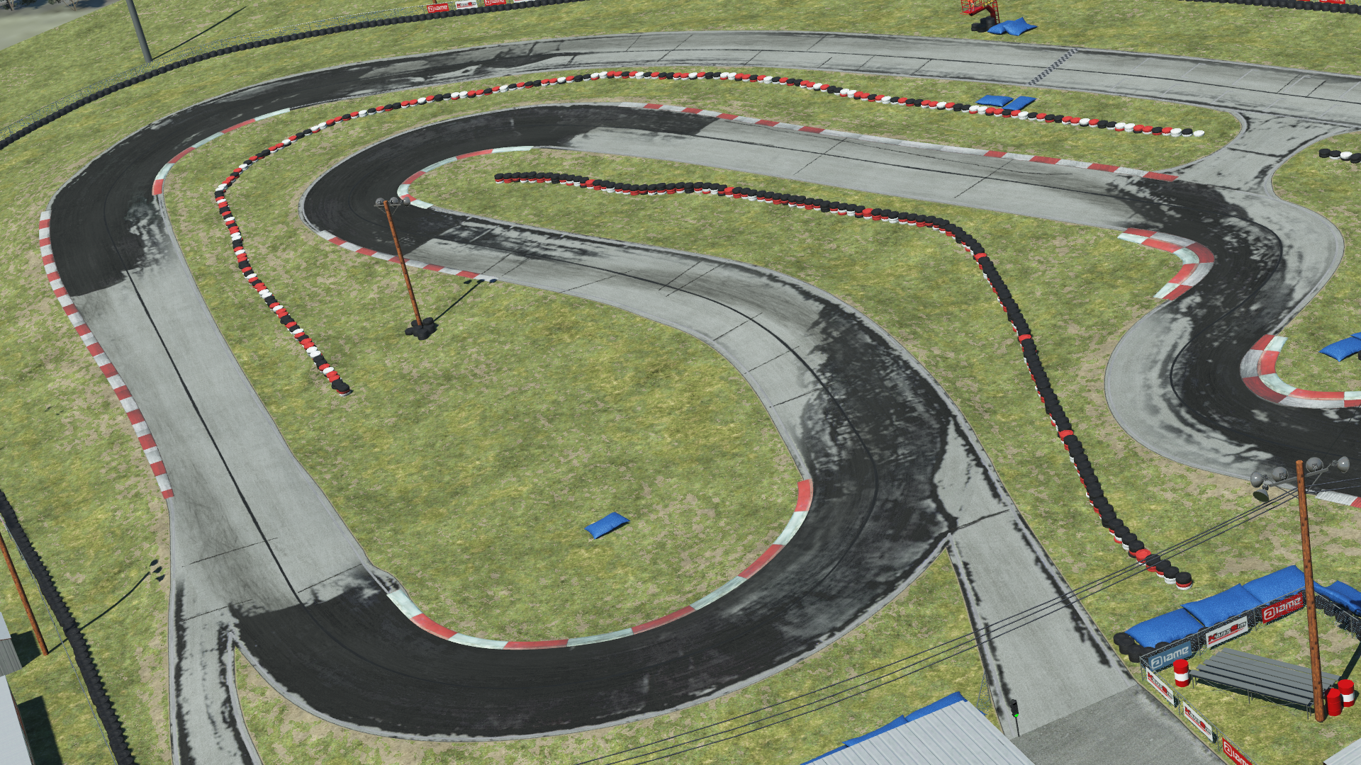 Overhead view of North Texas go-kart circuit with sharp curves, red and white barriers, and grassy terrain