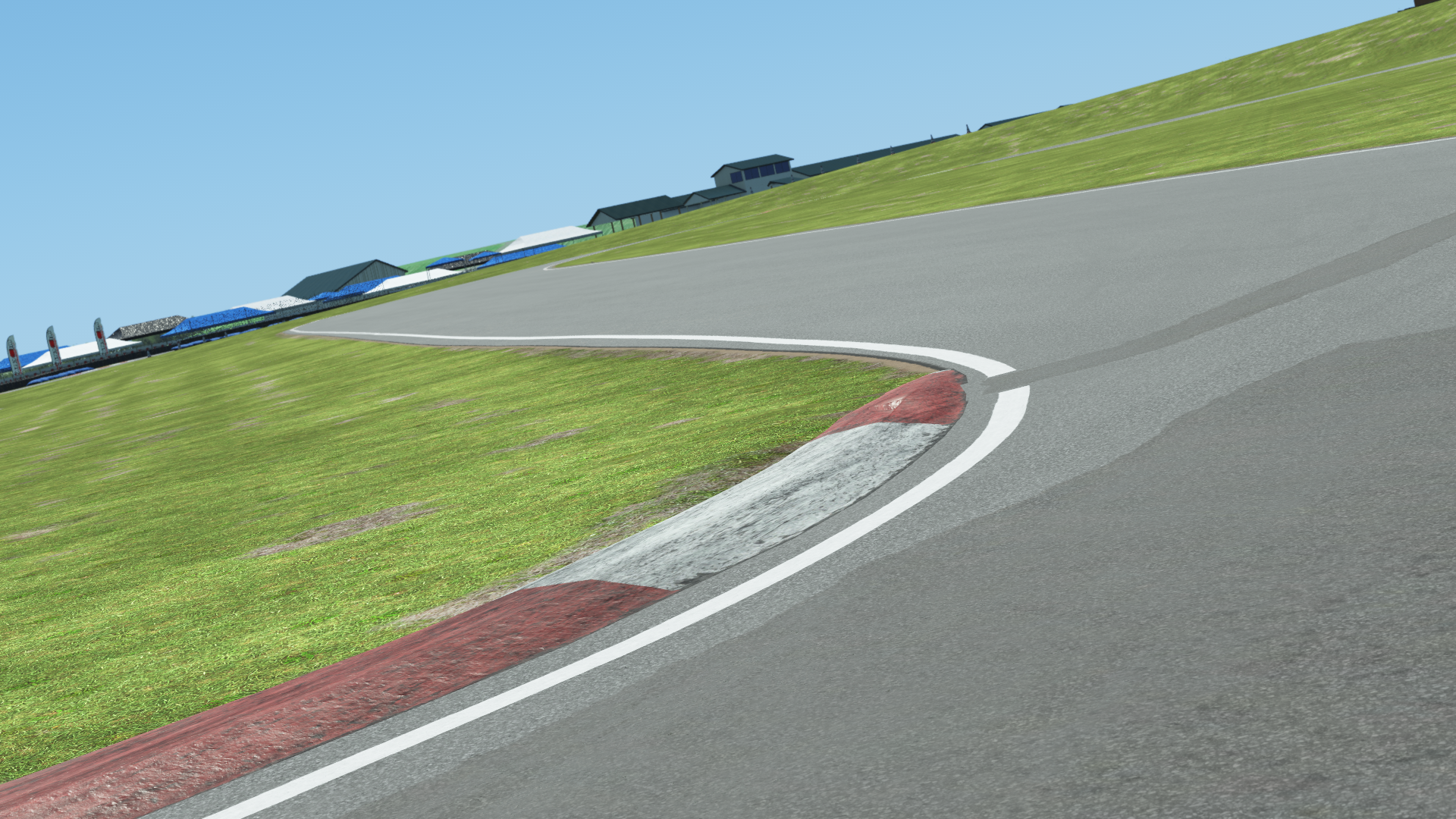 Pitt Race karting circuit close-up – red and white corner curb with elevation and track wear under blue sky